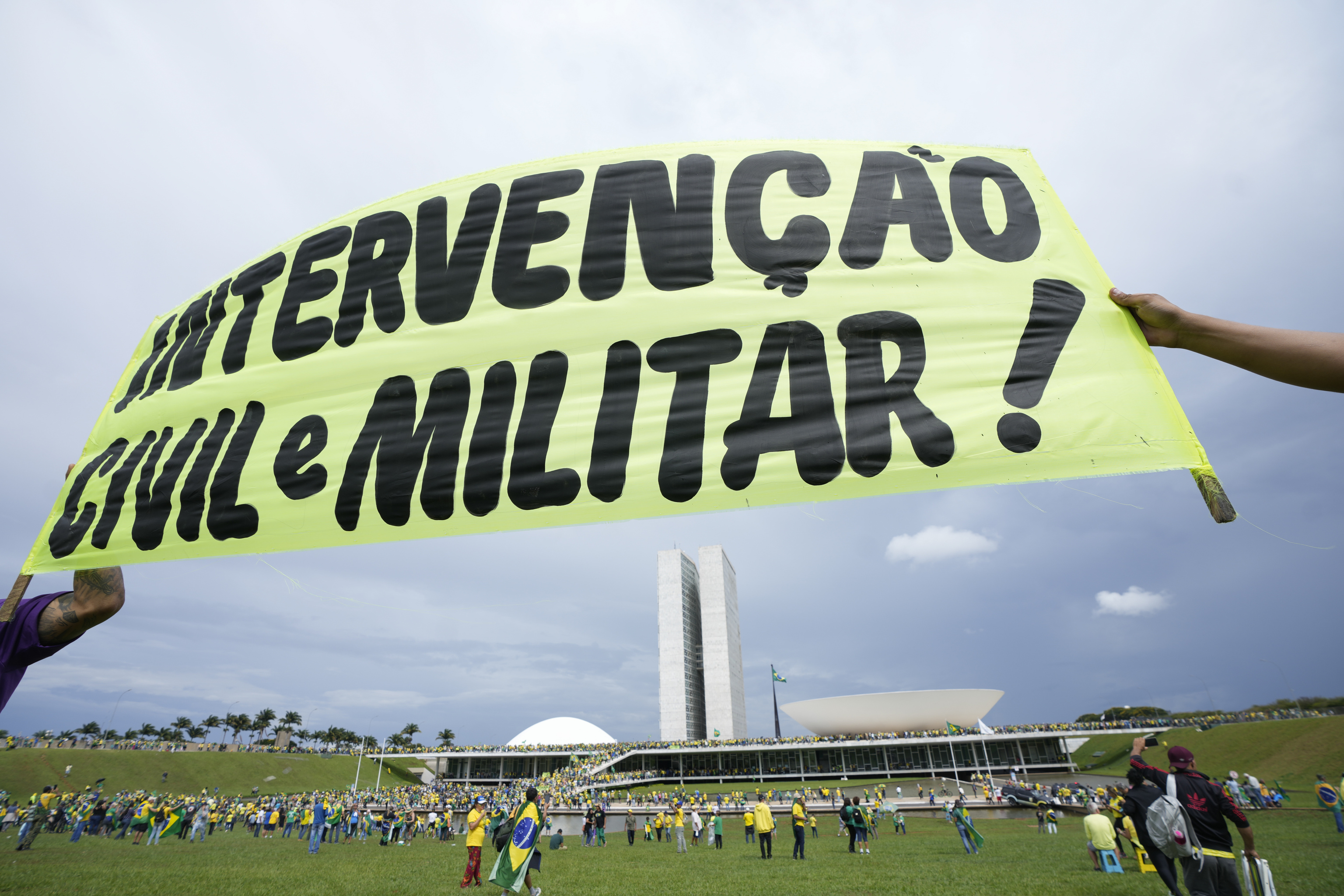 Protesters, supporters of  lt;HIT gt;Brazil lt;/HIT gt;'s former President Jair Bolsonaro, hold a banner that reads in Portuguese "Civil and Military Intervention!" as others storm the the National Congress building in Brasilia,  lt;HIT gt;Brazil lt;/HIT gt;, Sunday, Jan. 8, 2023. (AP Photo/Eraldo Peres)