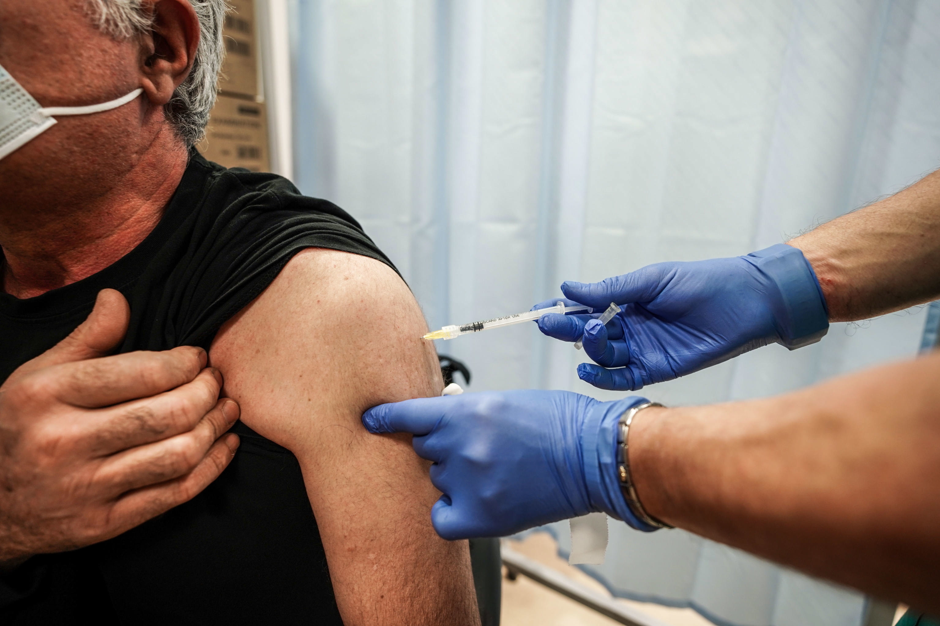 Un sanitario pone una dosis de refuerzo de la vacuna contra el Covid a un hombre en Turín (Italia).