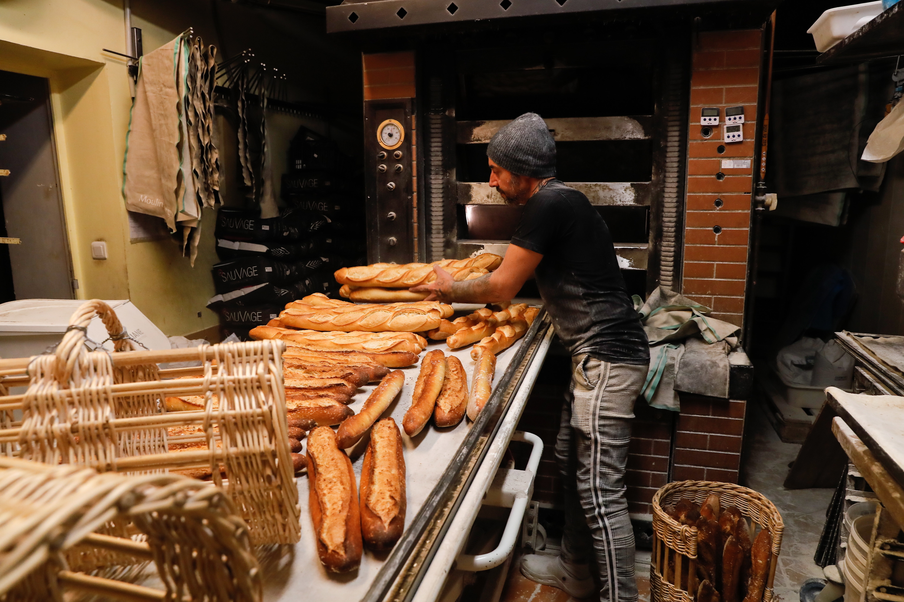 Un panadero elabora pan en un establecimiento de París.