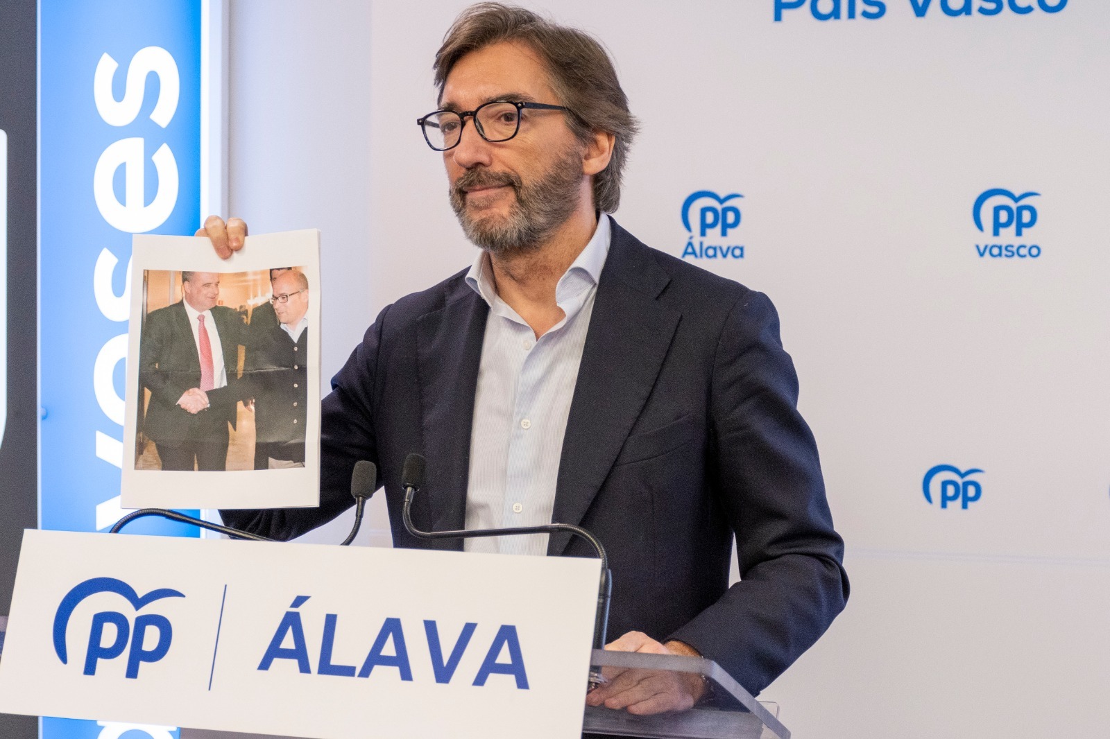 El presidente del PP de lava muestra la foto del abrazo de Egibar a Alfredo de Miguel.