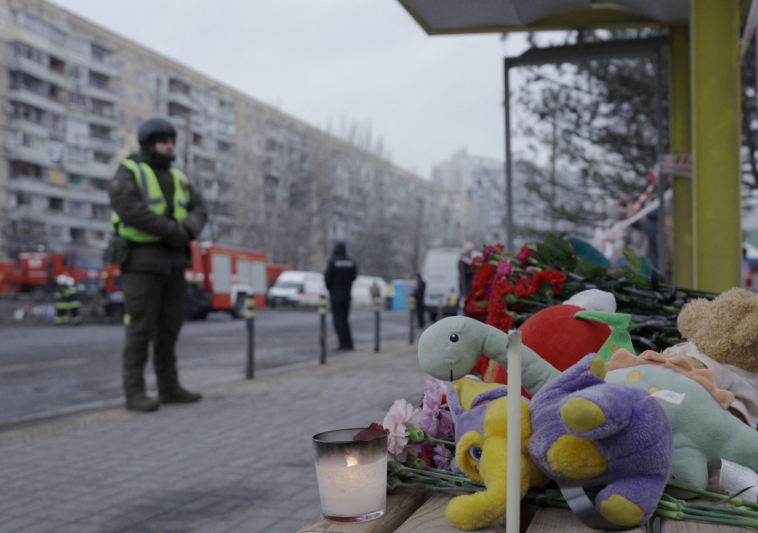 Velas, flores y juguetes infantiles frente al edificio residencial destruidopor un ataque con misiles en Dnipro.