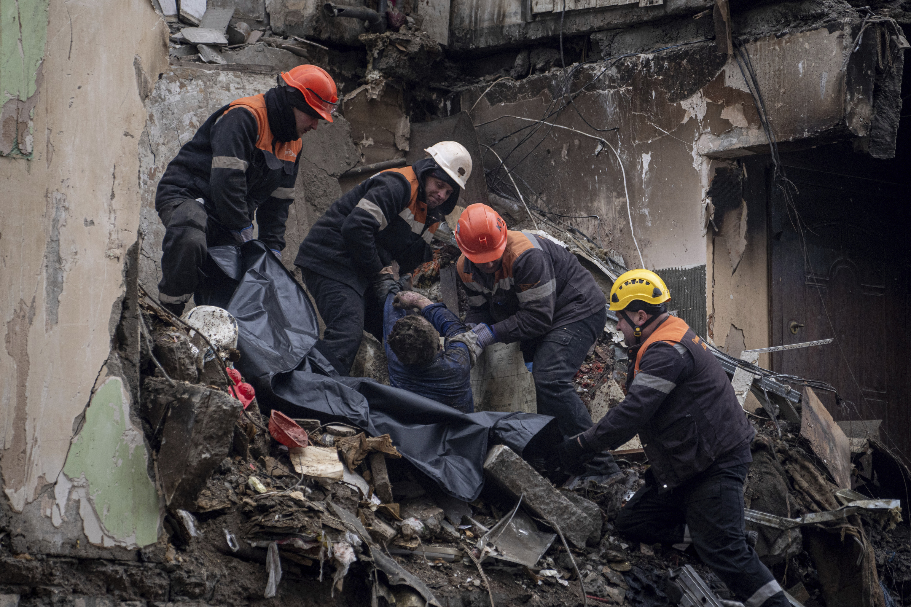 Trabajadores de rescate trasladan el cuerpo de un hombre muerto en un ataque a un edificio de Dnipro.