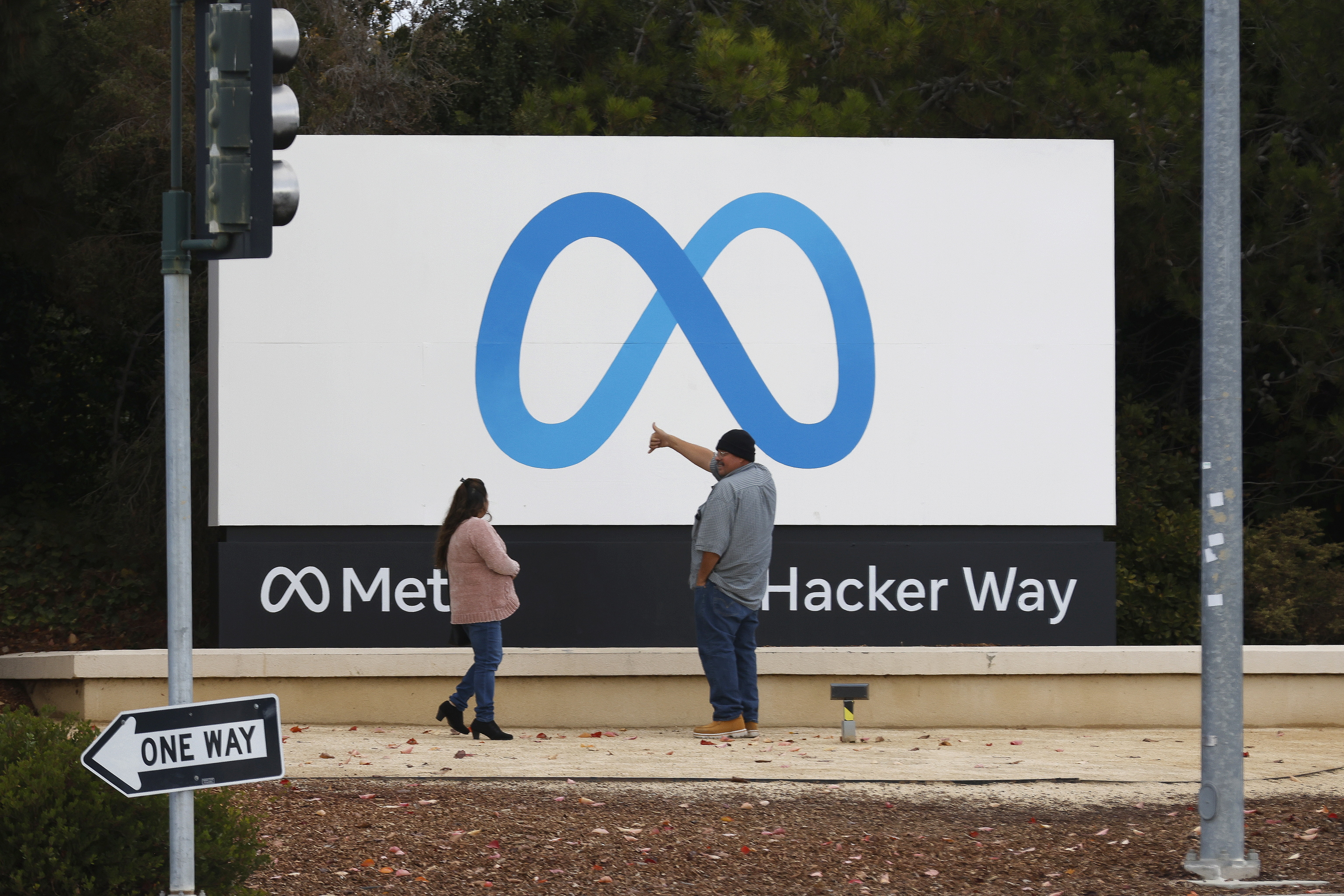 Dos personas frente a la sede de Meta en  Menlo Park, California.