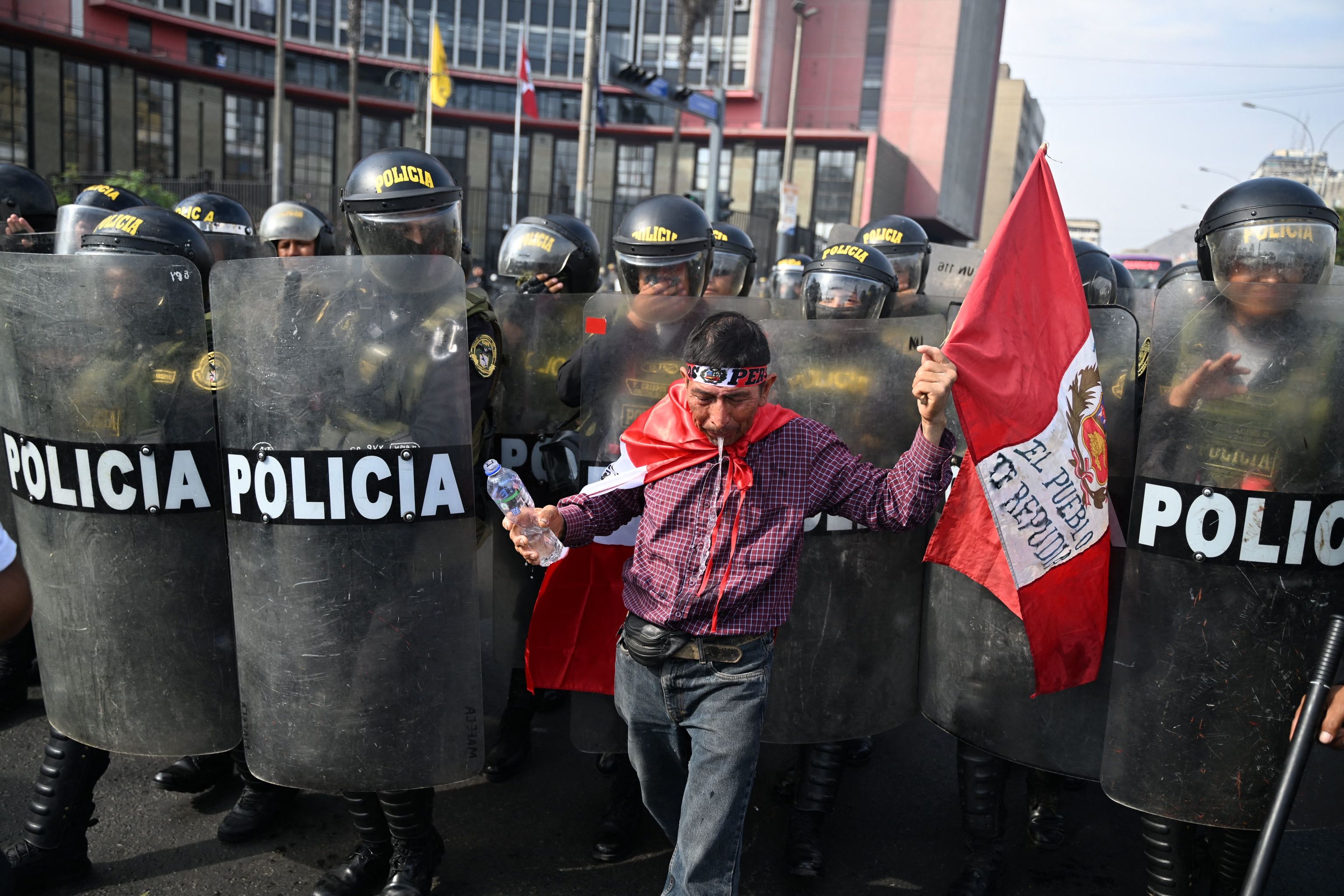 Un manifestante escupe agua frente a la polica, en Lima, este jueves.