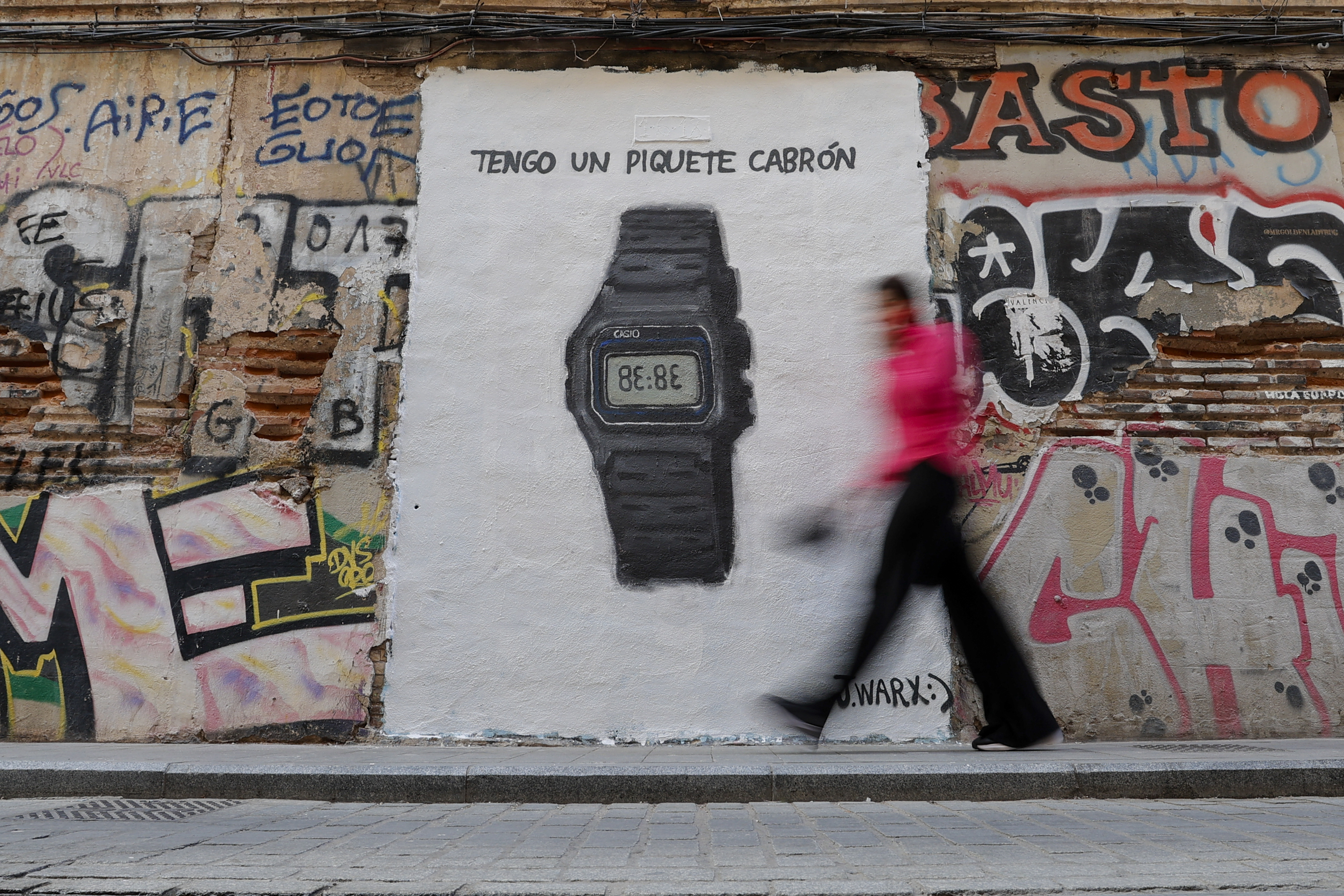 Una persona pasa ante un grafiti del grafitero J.Warx que alude al último éxito de la cantante colombiana Shakira.