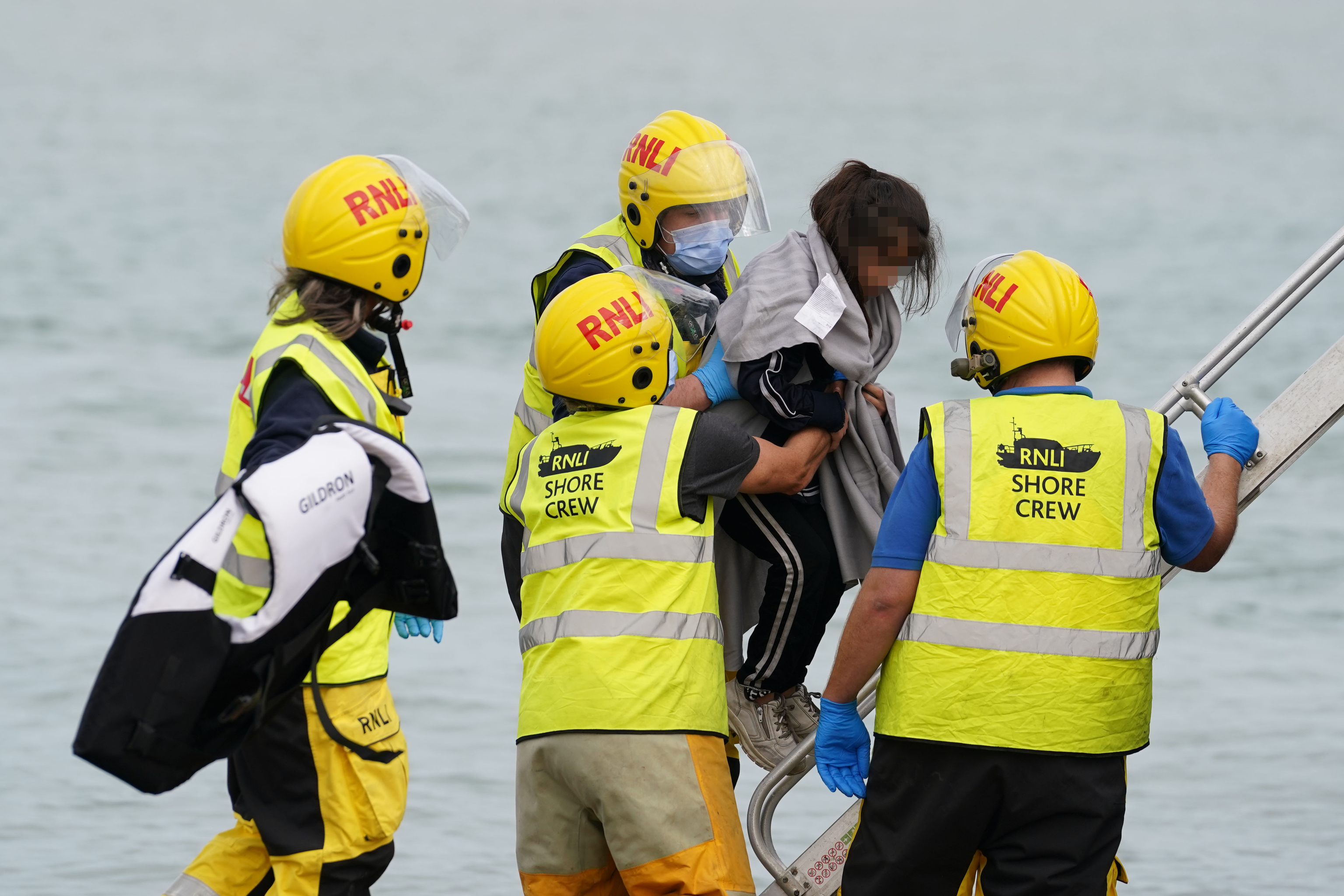 Un niño migrante en la playa de Dungeness tras ser rescatado por el RNLI.
