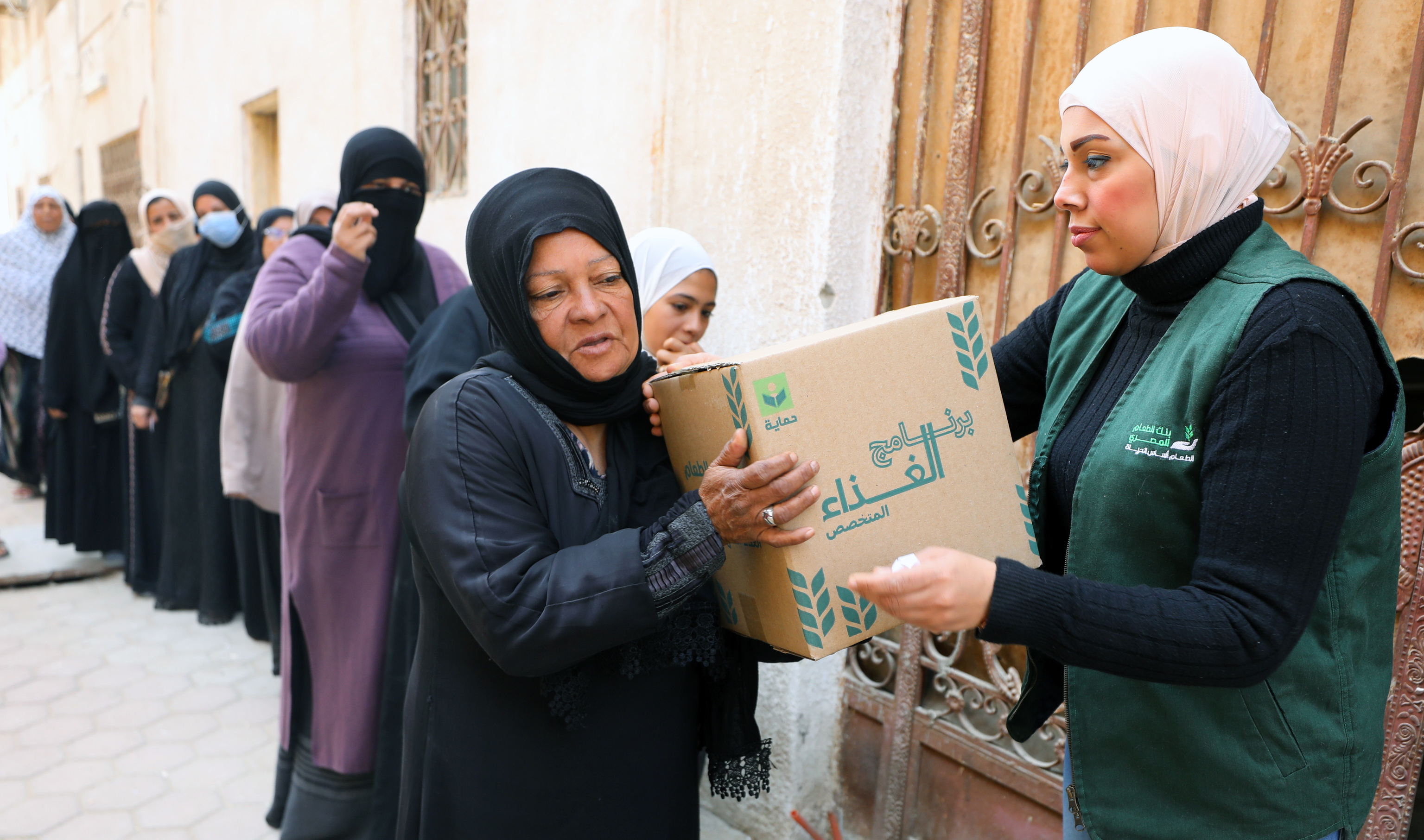 Una mujer recibe una caja de alimentos de una ONG en El Cairo.