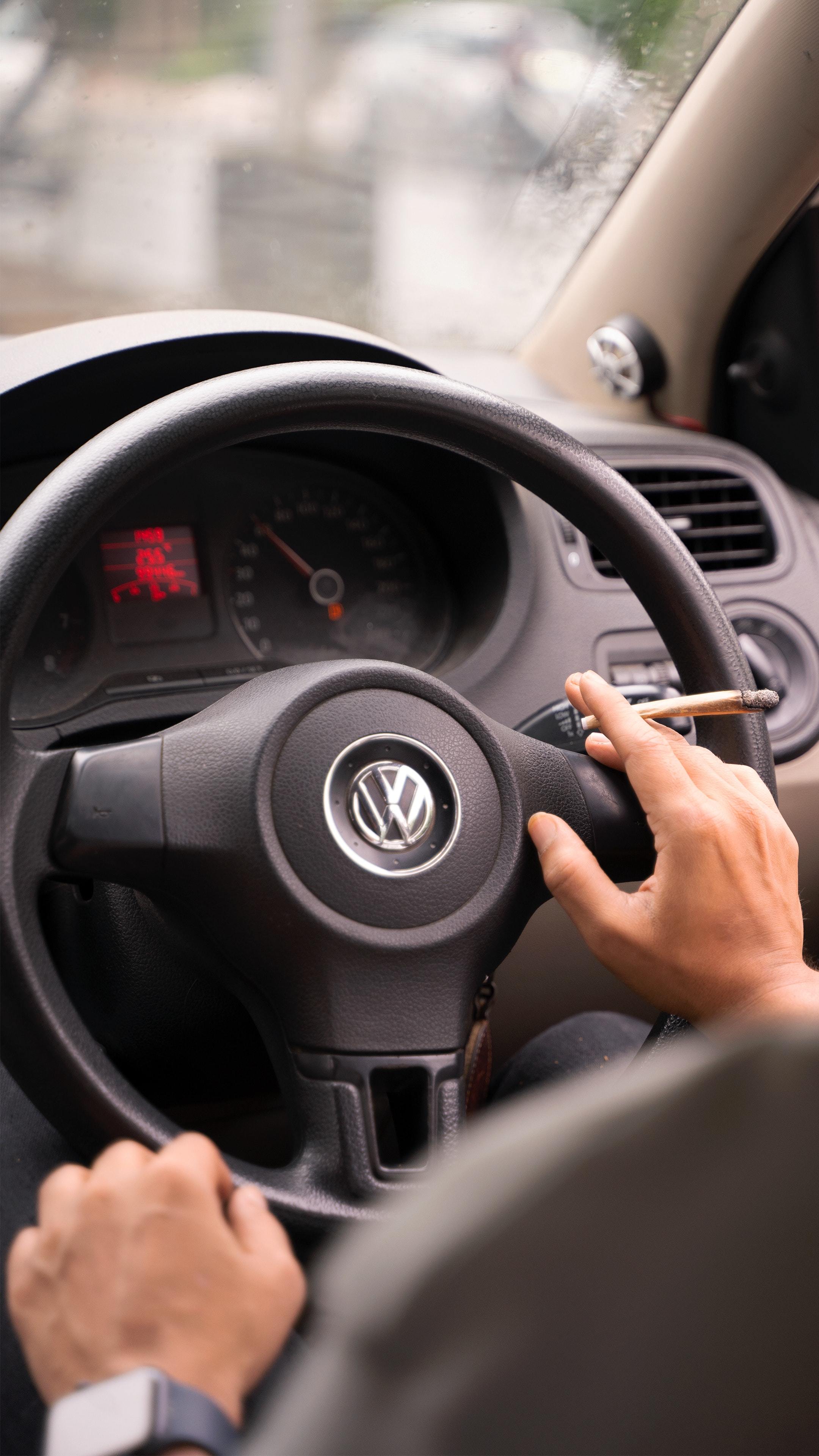 Un conductor al volante con un cigarrillo en la mano.