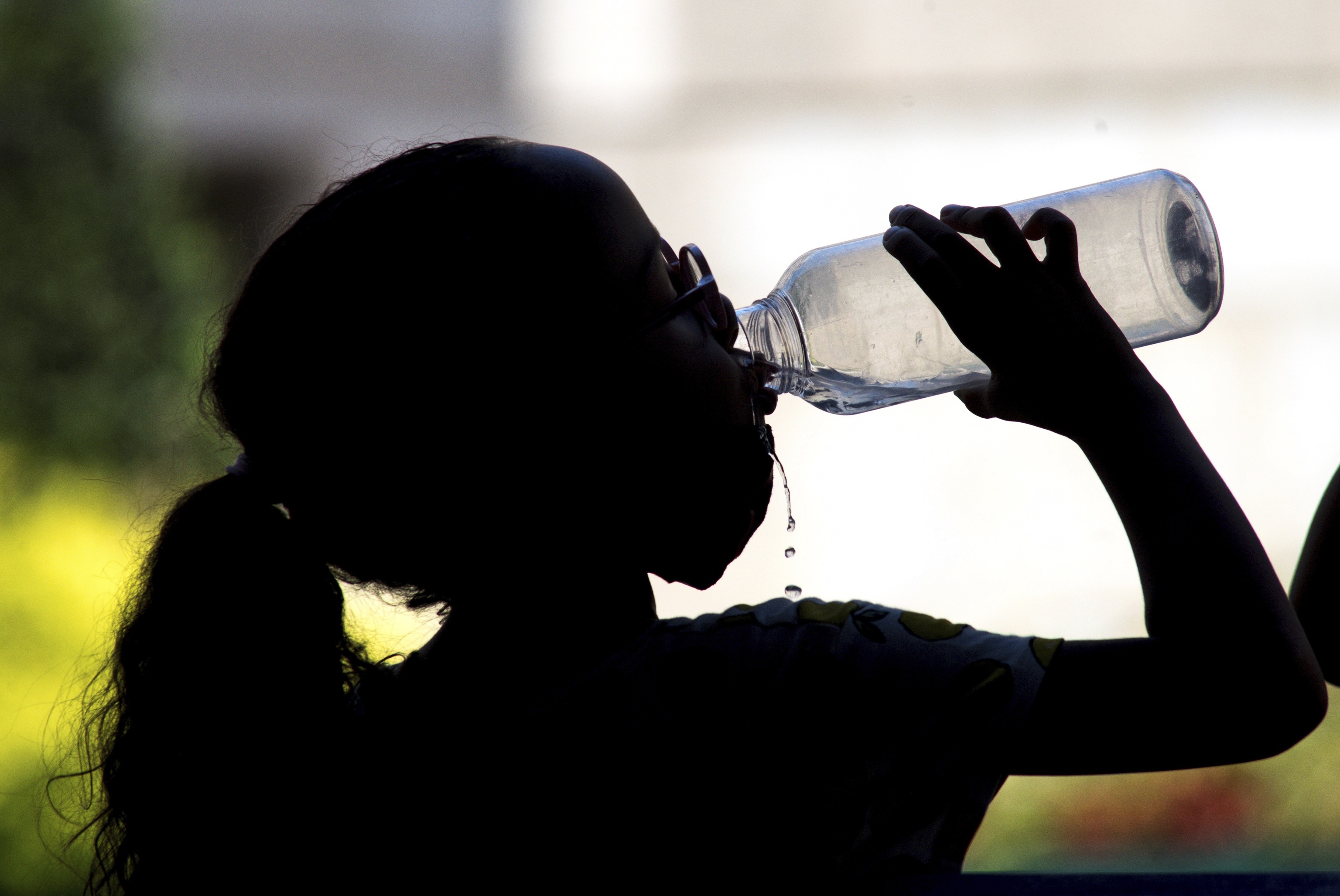 Una niña bebe agua en el centro de Ourense durante la alerta por altas temperaturas del pasado verano.