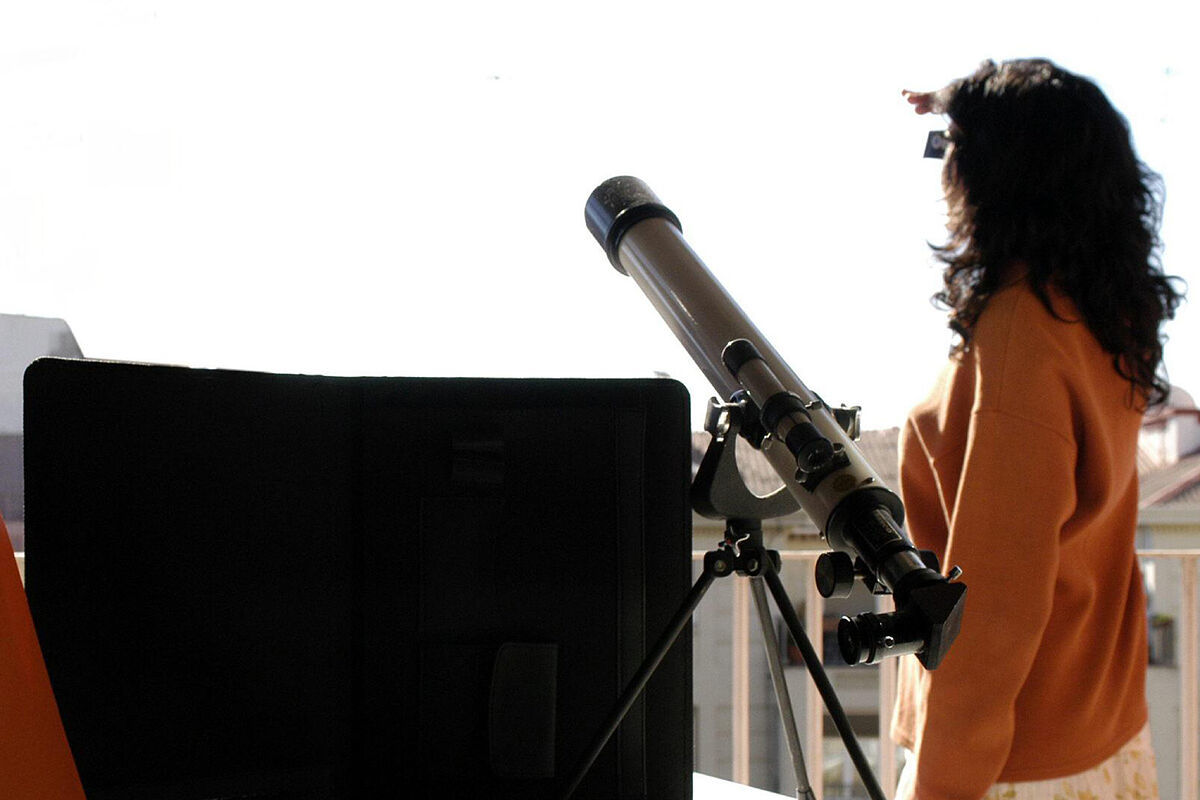 Una investigadora astronómica siguiendo la evolución de un eclipse solar desde Zaragoza.
