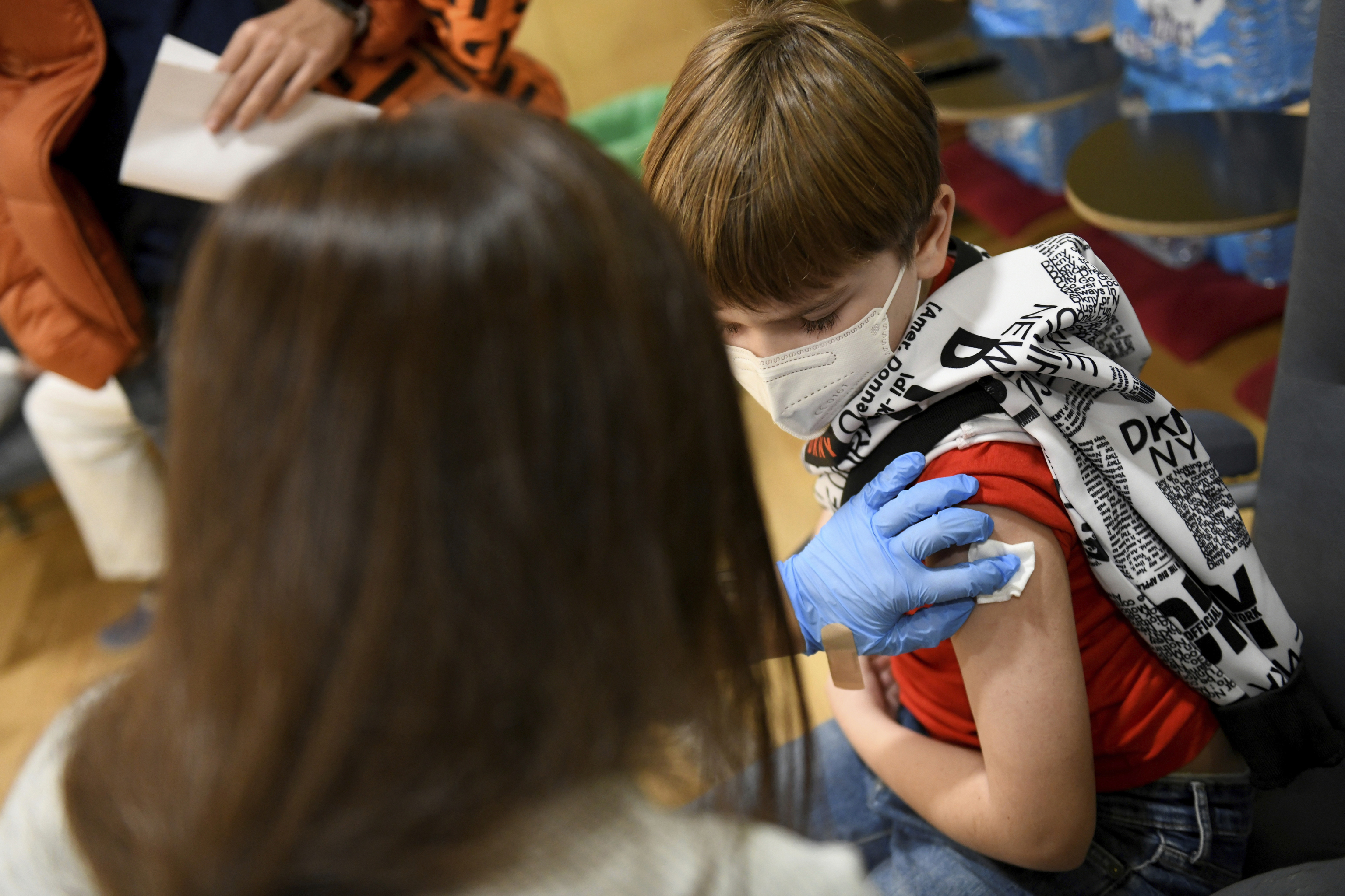 Una profesional sanitaria administra una vacuna a un niño en la Comunidad de Madrid.