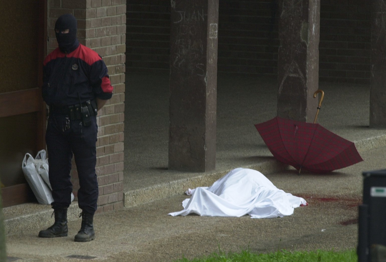 El cuerpo de Jos Luis Lpez de Lacalle, tapado con una sbana, junto a un charco de sangre, su paraguas y los peridicos que acababa de comprar, tras ser asesinado por ETA el 7 de mayo de 2000.