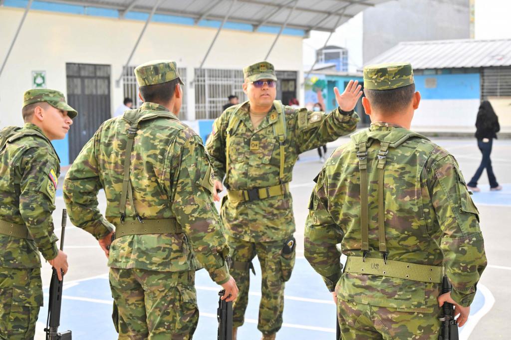 Militares ecuatorianos, este domingo, custodian un centro de votaciones.