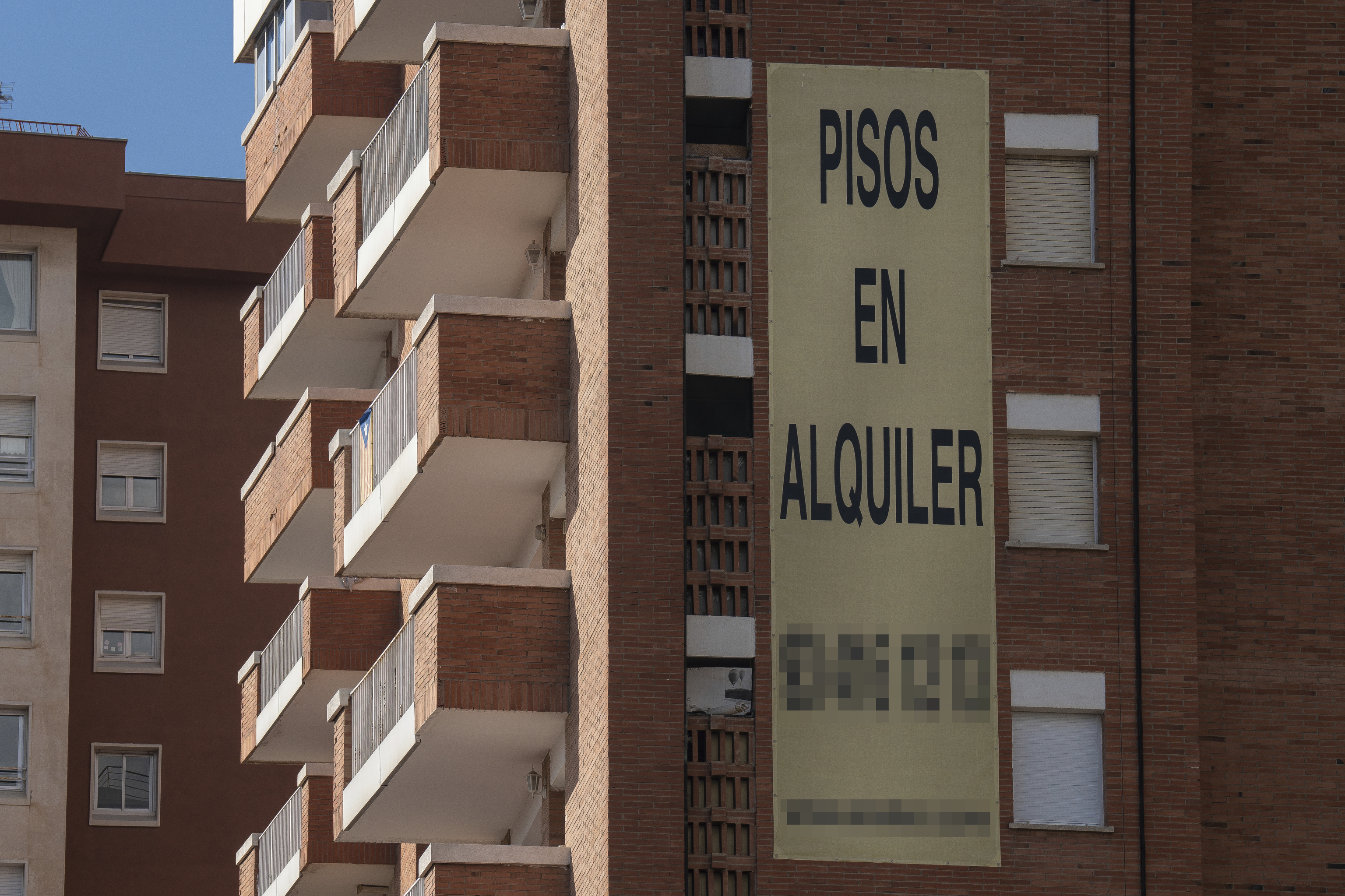 Cartel de alquiler de viviendas en la fachada de un edificio.
