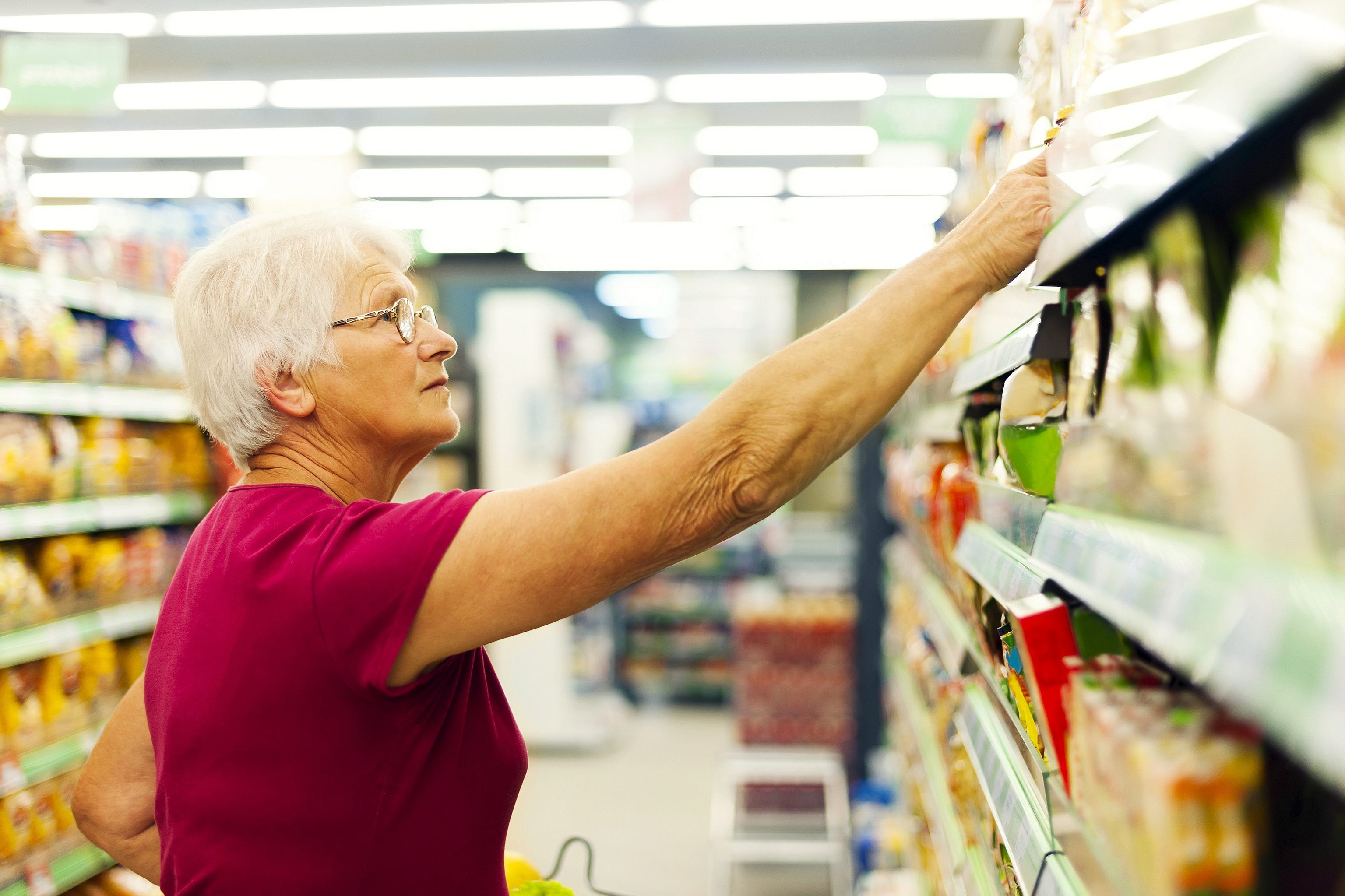 Una mujer jubilada comprando en un supermercado.