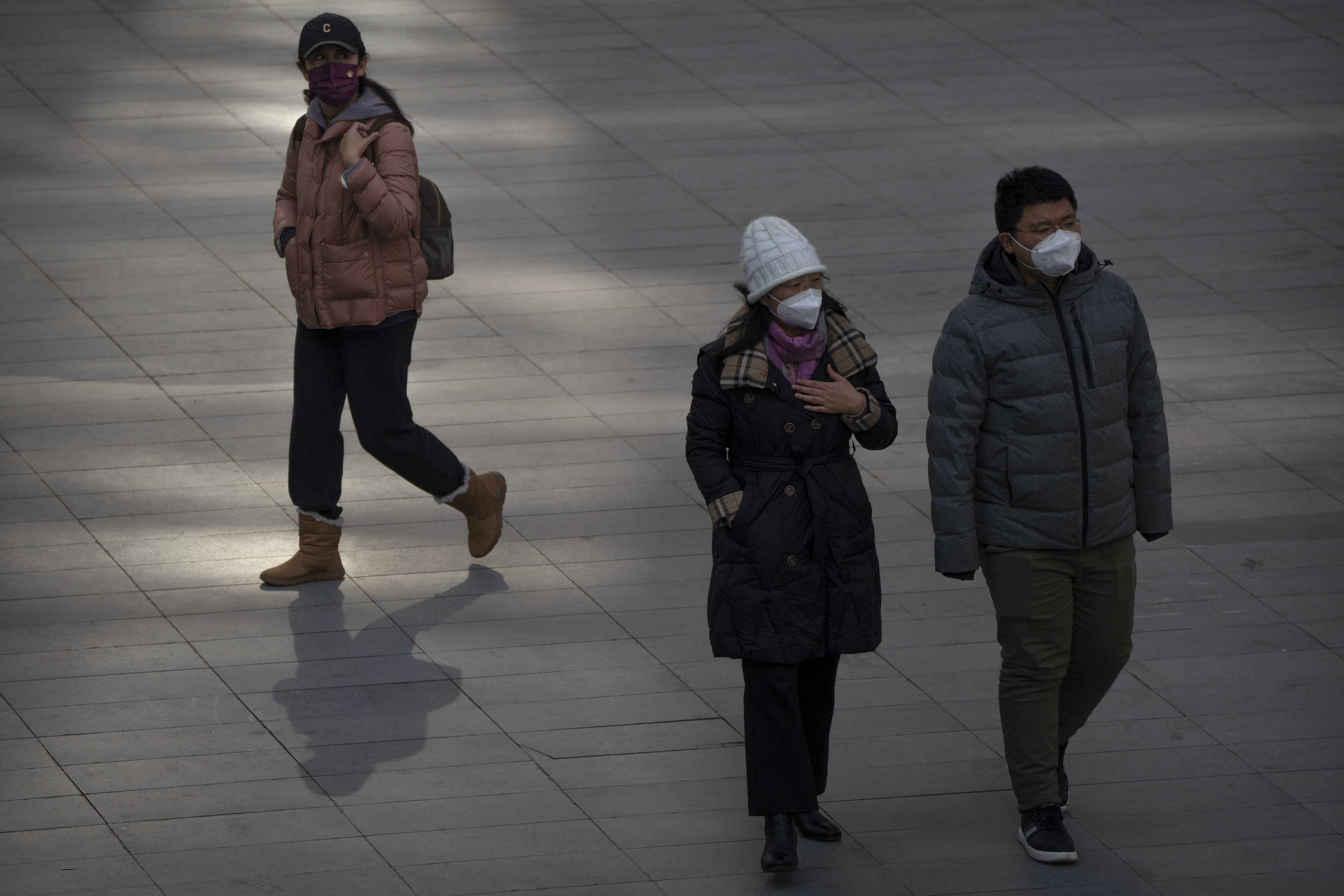 Personas paseando con mascarillas paseando por un complejo de oficinas en Beijing, el pasado martes 7 de febrero.