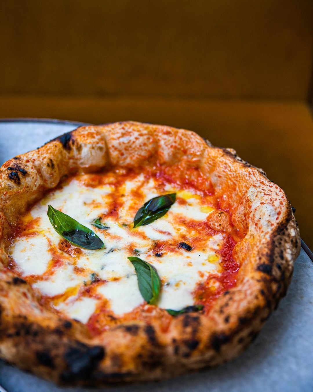 La pizza napolitana auténtica solo lleva tomate, mozzarella y hojas de albahaca fresca.