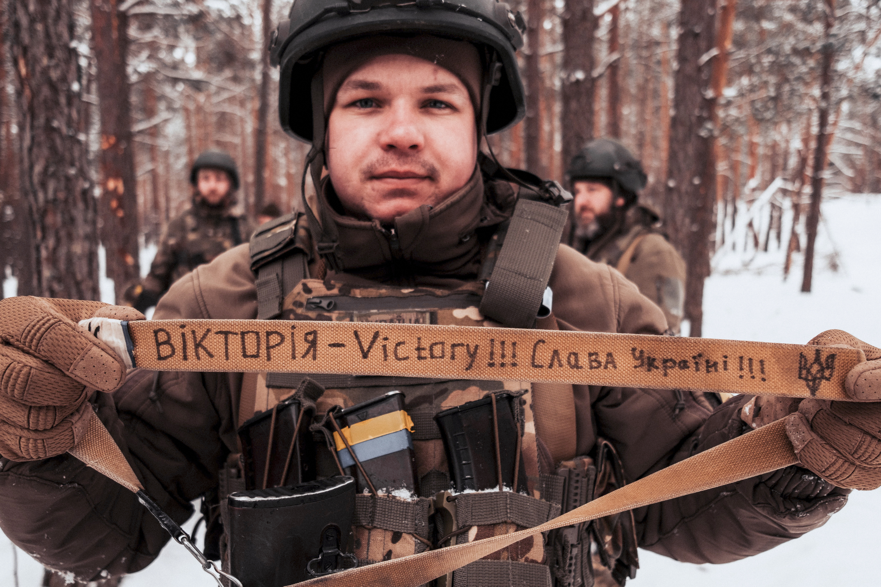 Oled, soldado de la Brigada 115 muestra la correa de su arma con el mensaje "Victoria Ucrania".