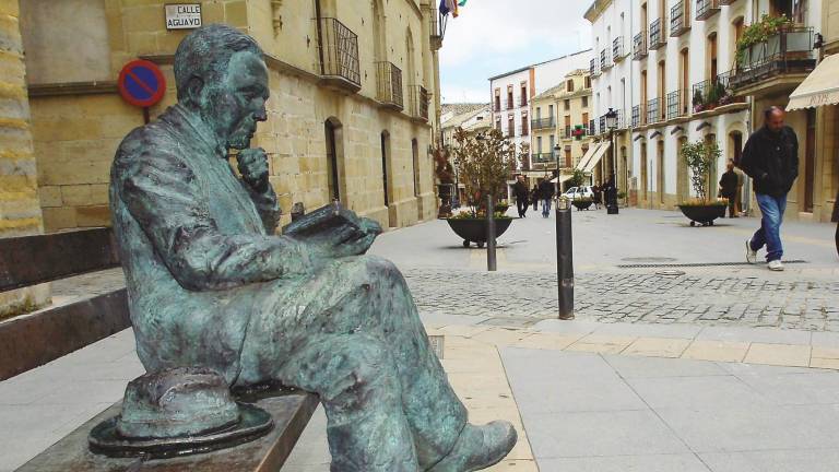 Escultura de Machado, sentado en un banco leyendo en la calle San Pablo de Baeza.