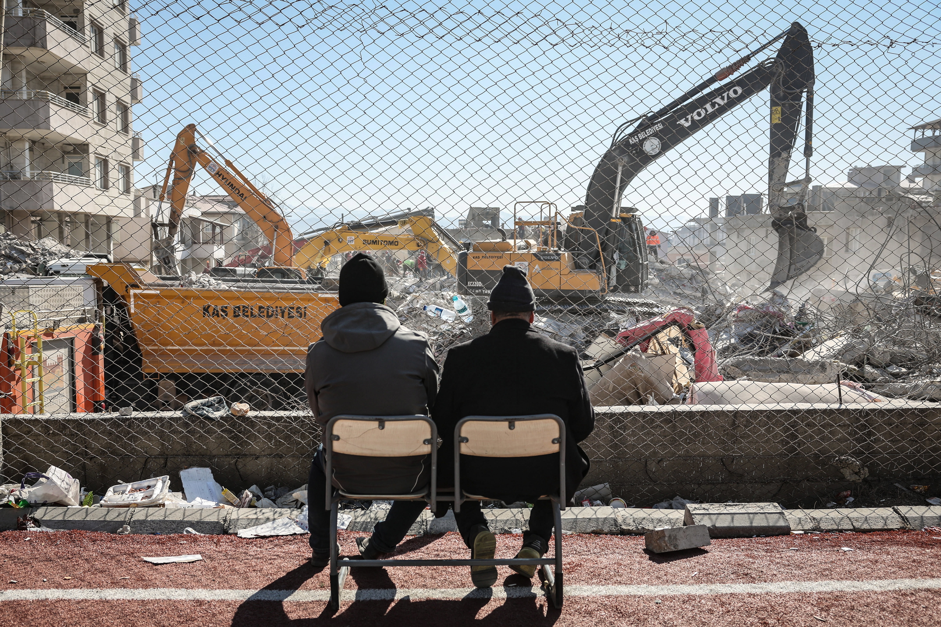 Dos hombres observan las excavadoras tras el terremoto, en Nurdagi, el lunes.