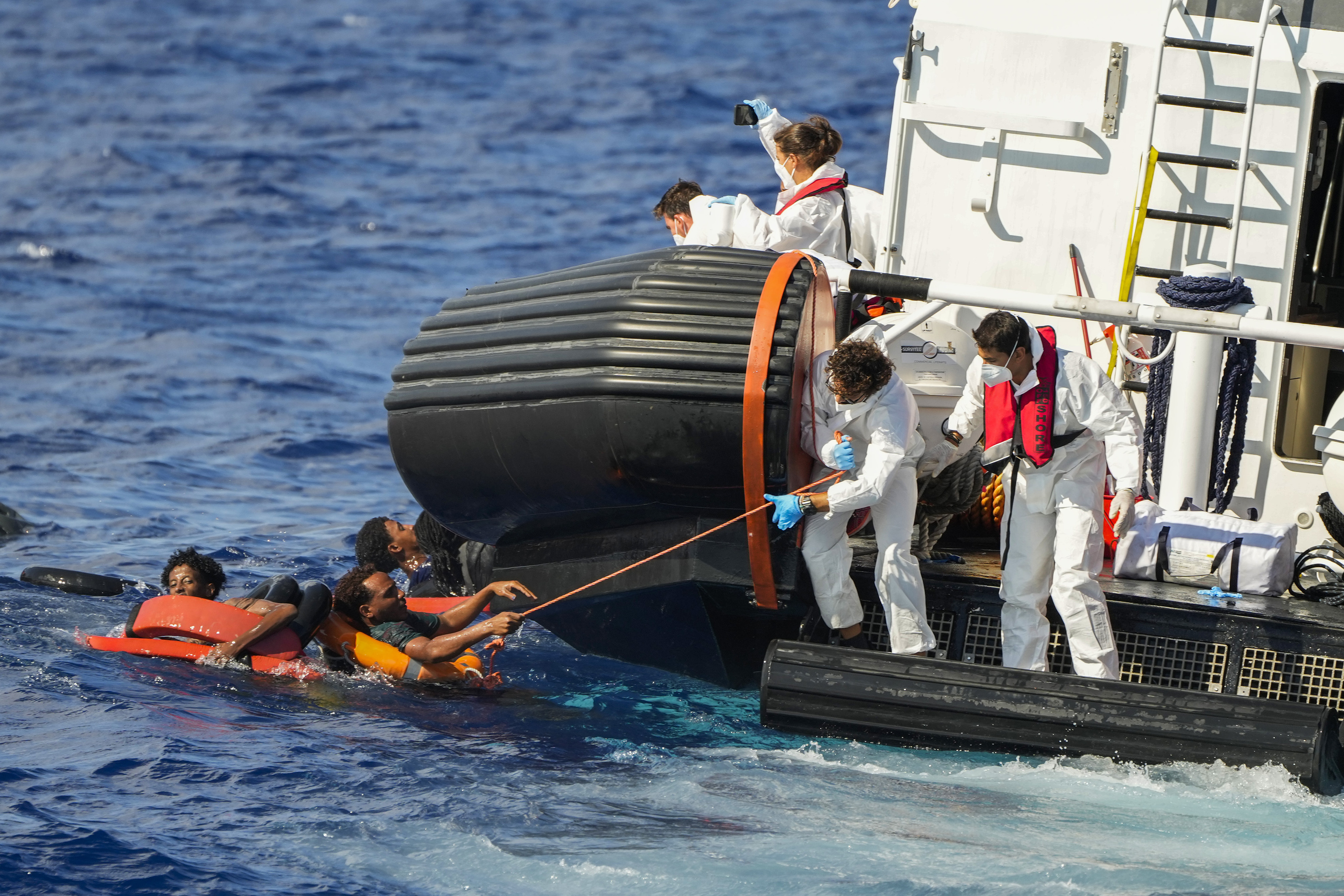 Miembros de salvamento maritimo italiano rescatan a varios inmigrantes cerca de la costa de Lampedusa.