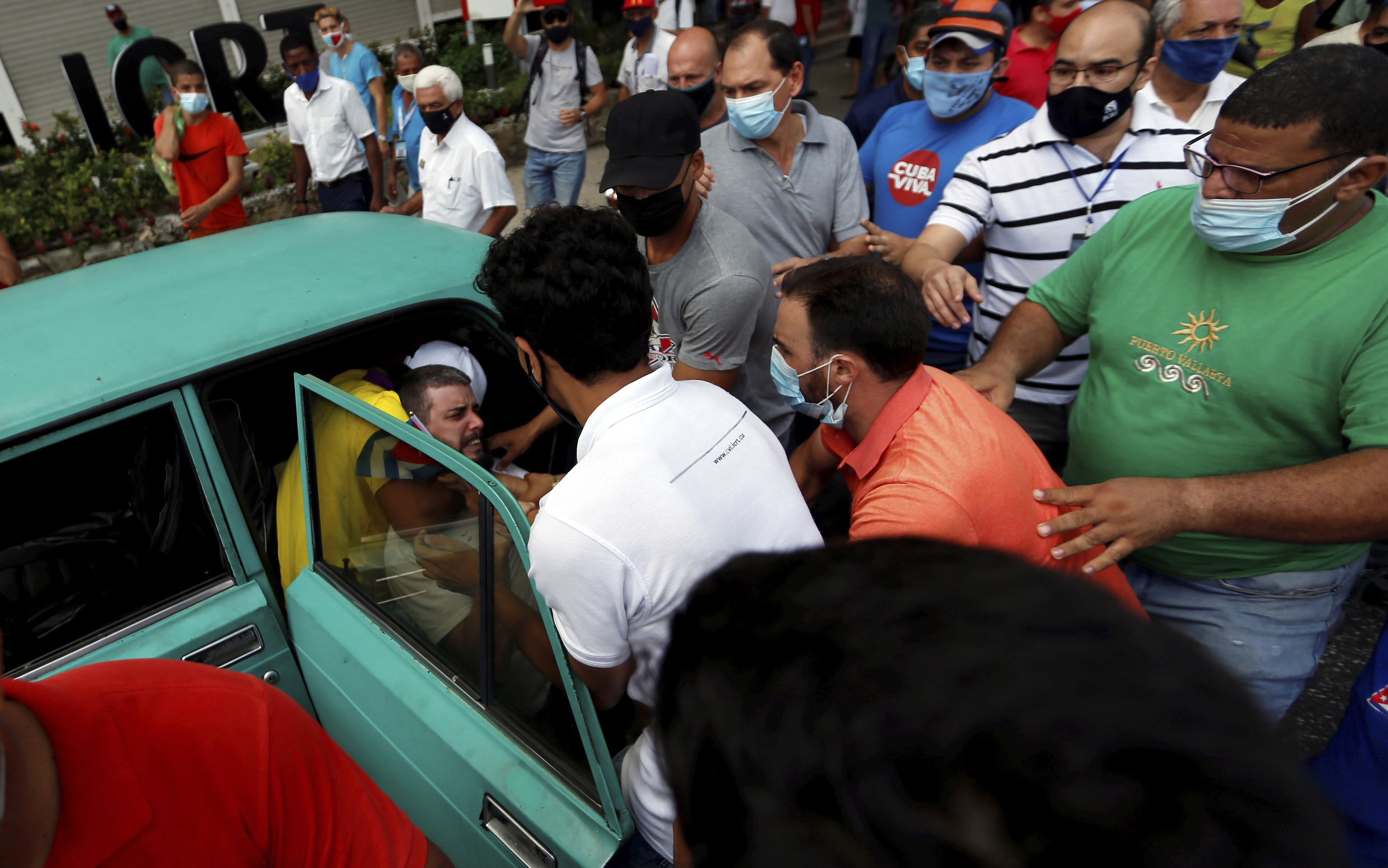 Un manifestante es metido a la fuerza en un coche, en La Habana.