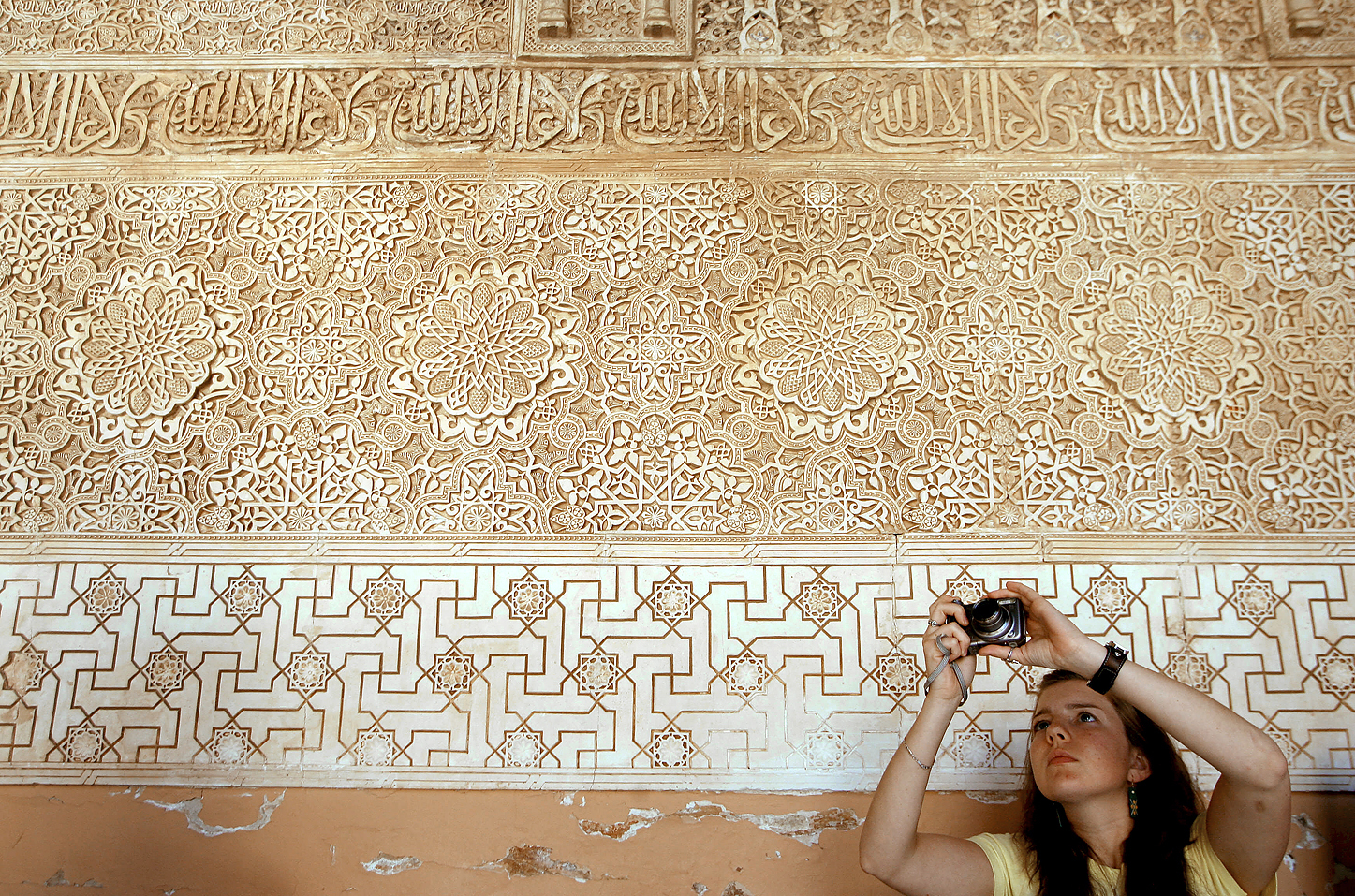 Una turista toma una foto de unas yeseras en la Alhambra, Granada.