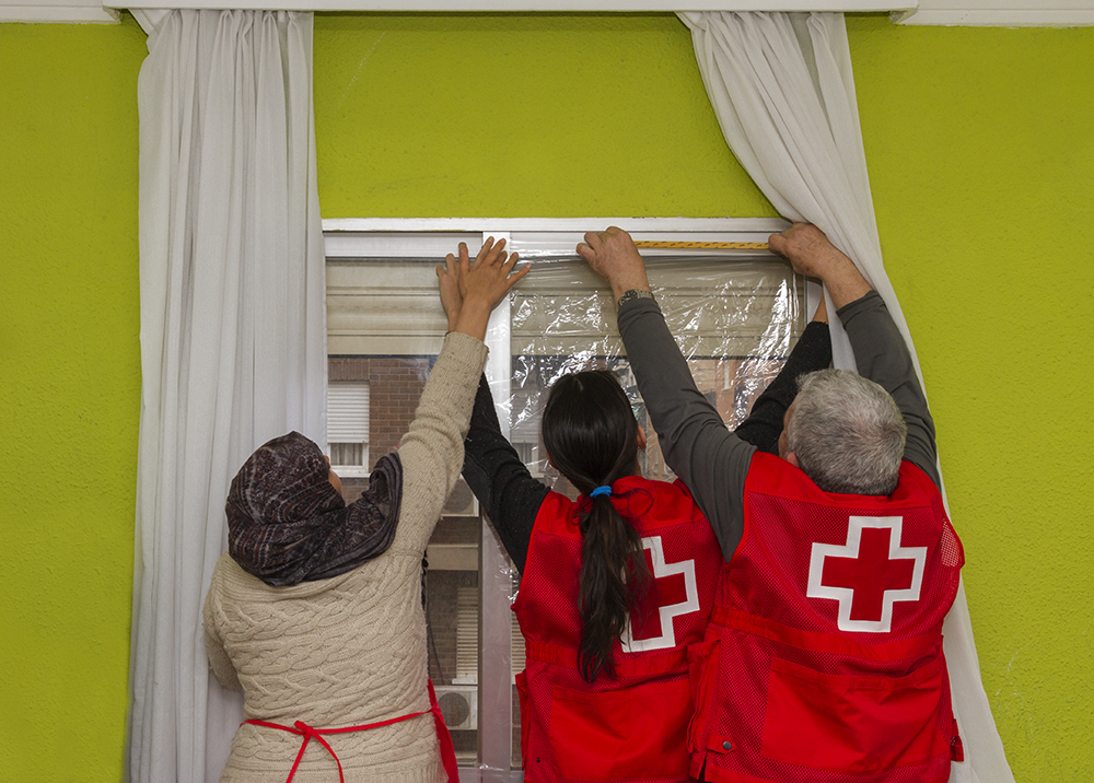 Voluntarios de Cruz Roja mejoran el cierre de una ventana para evitar el fro