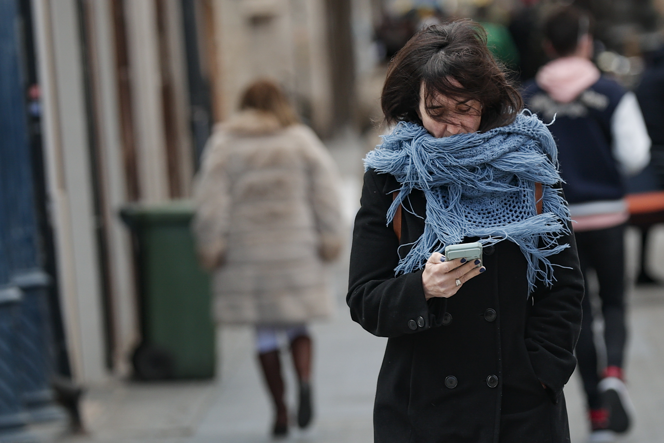 Una mujer protegida contra el viento y el frio