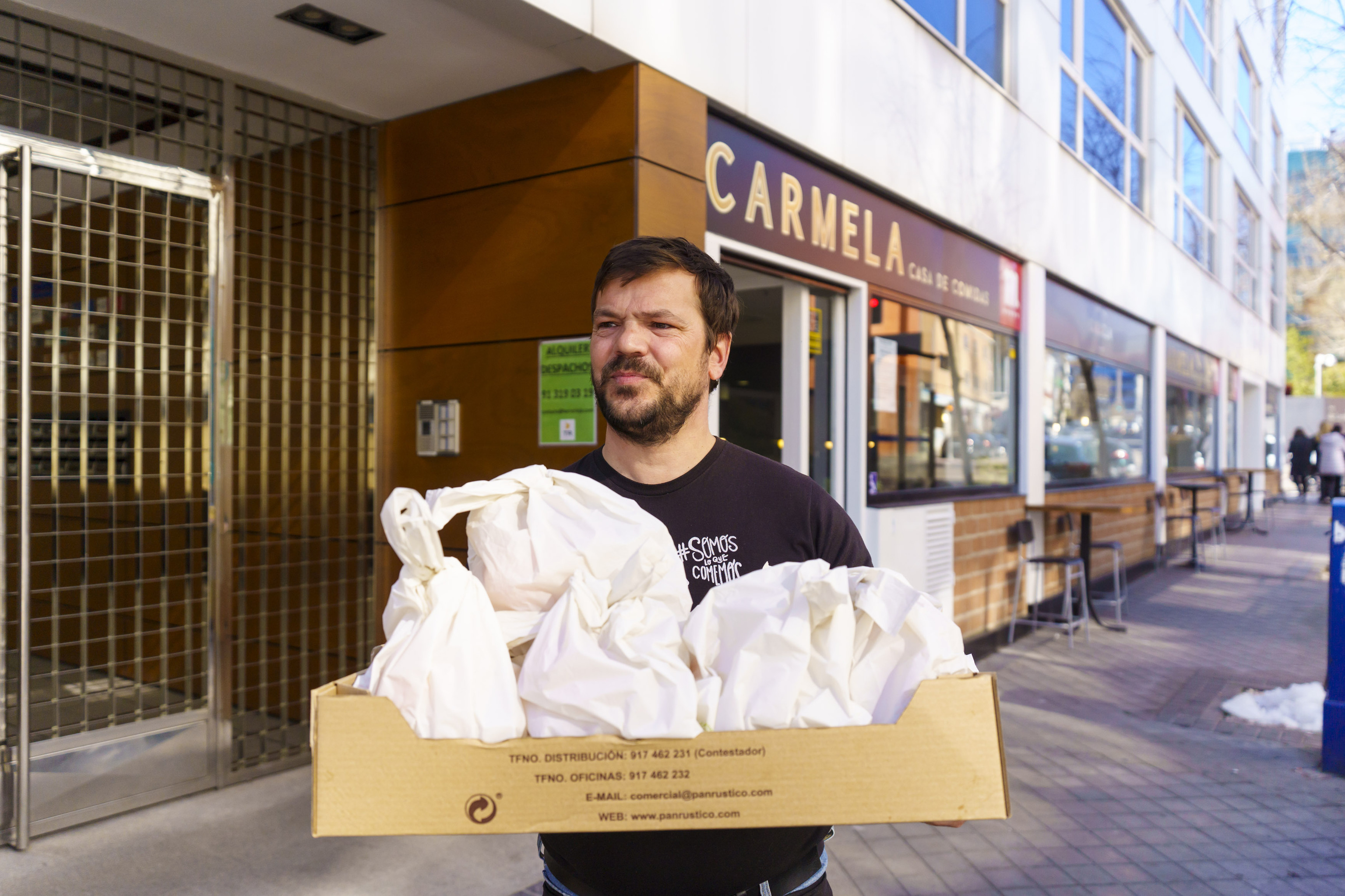 Jaime Rincn, fundador de 'Comida para todos', carga una caja de mens solidarios.