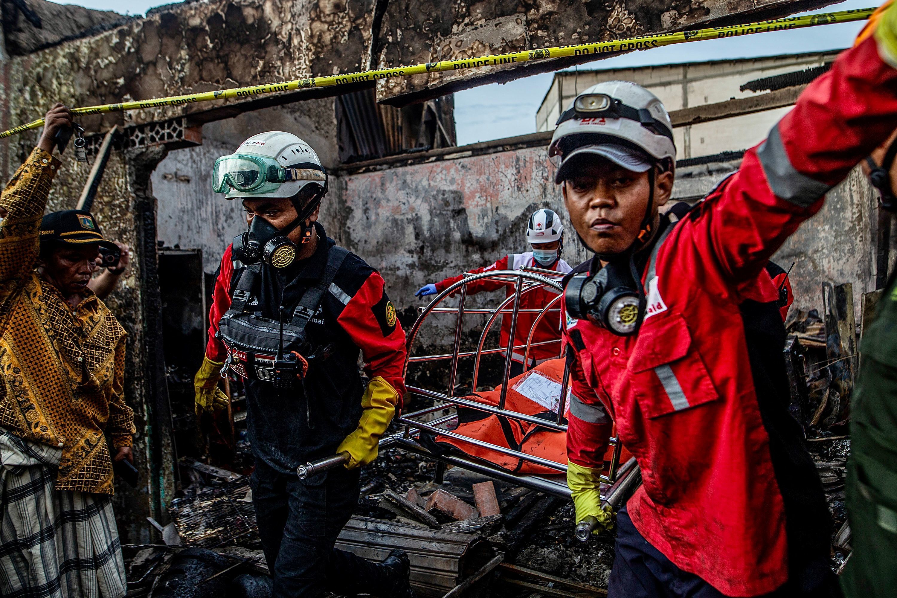 Los bomberos evacuan el cuerpo de una vctima de una casa en una zona residencial de Plumpang, al norte de Yakarta, el 4 de marzo de 2023, tras un incendio en un depsito de combustible estatal cercano gestionado por la empresa energtica Pertamina.