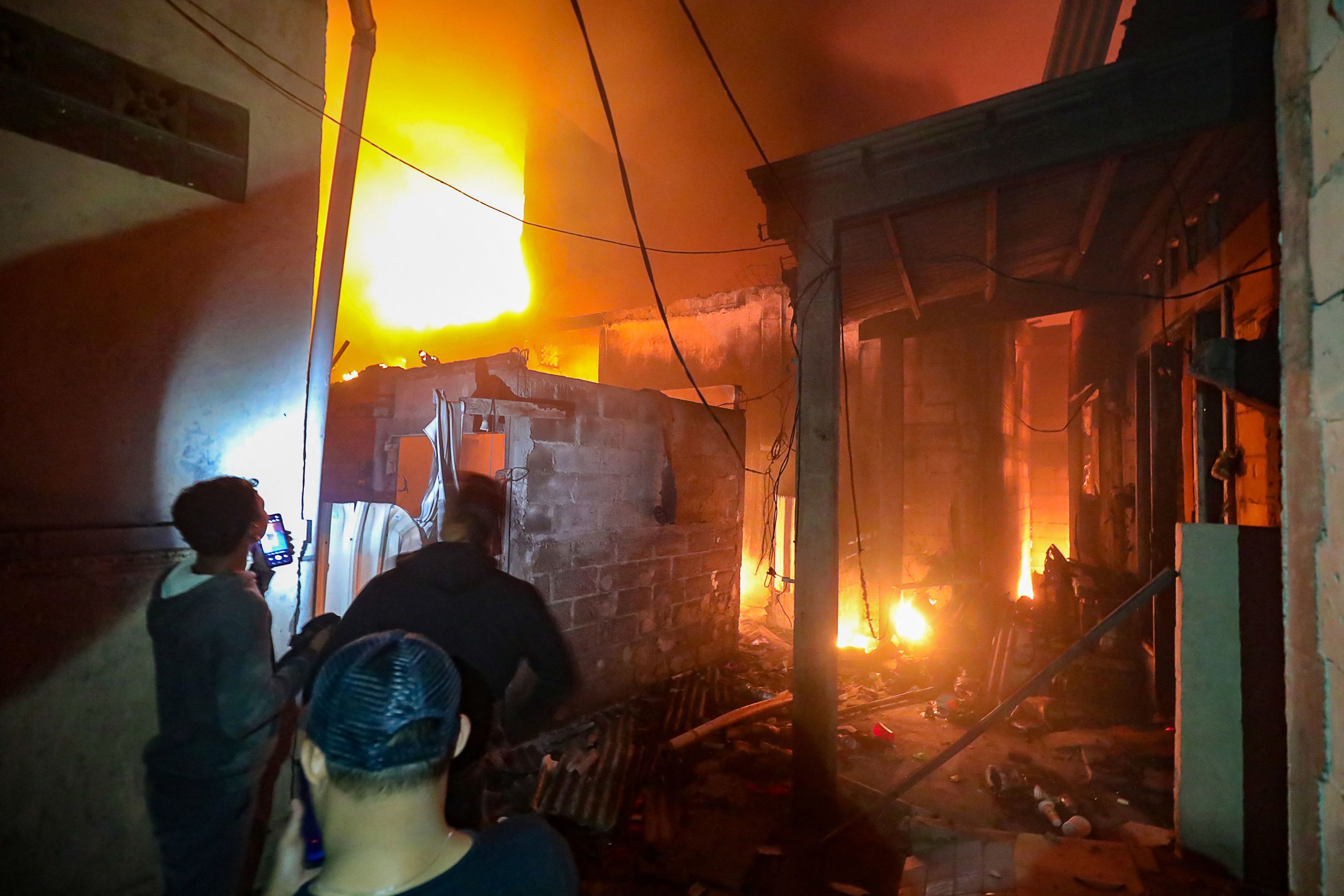 Residentes tratan de encontrar vctimas de sus casas quemadas en una zona residencial situada cerca del lugar del incendio del depsito de combustible propiedad de la compaa estatal de petrleo y gas Pertamina, en Plumpang, Yakarta, el 3 de marzo de 2023. - Al menos 14 personas murieron y decenas resultaron heridas en la capital de Indonesia el 3 de marzo de 2023 tras declararse un incendio de grandes proporciones en un depsito de combustible estatal antes de que los bomberos lo controlaran, segn inform el ejrcito.