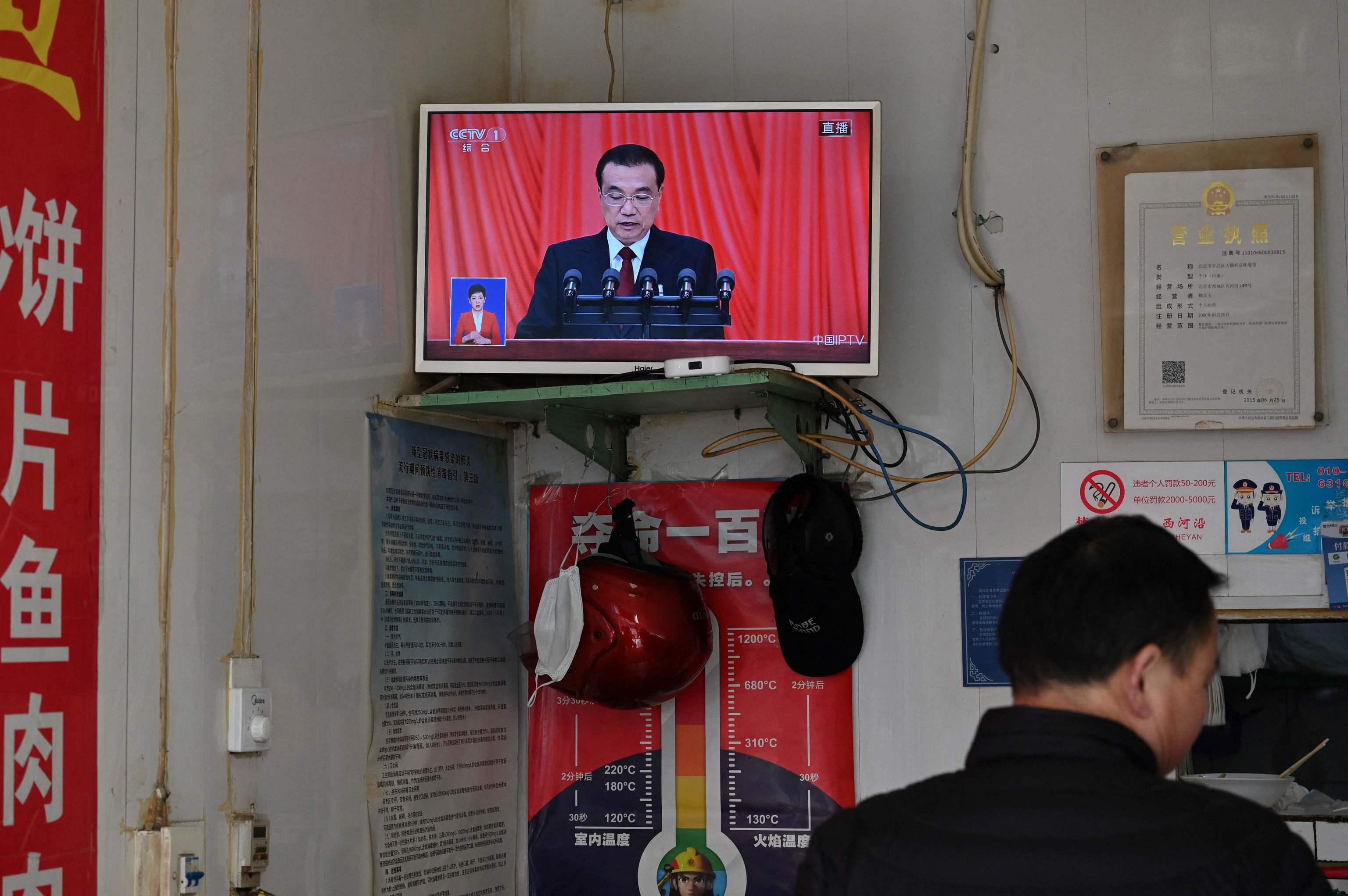 Una pantalla de televisin en un restaurante muestra la cobertura en directo del primer ministro chino Li Keqiang leyendo su informe de trabajo durante la sesin de apertura de la Asamblea Popular Nacional en Pekn el 5 de marzo de 2023.