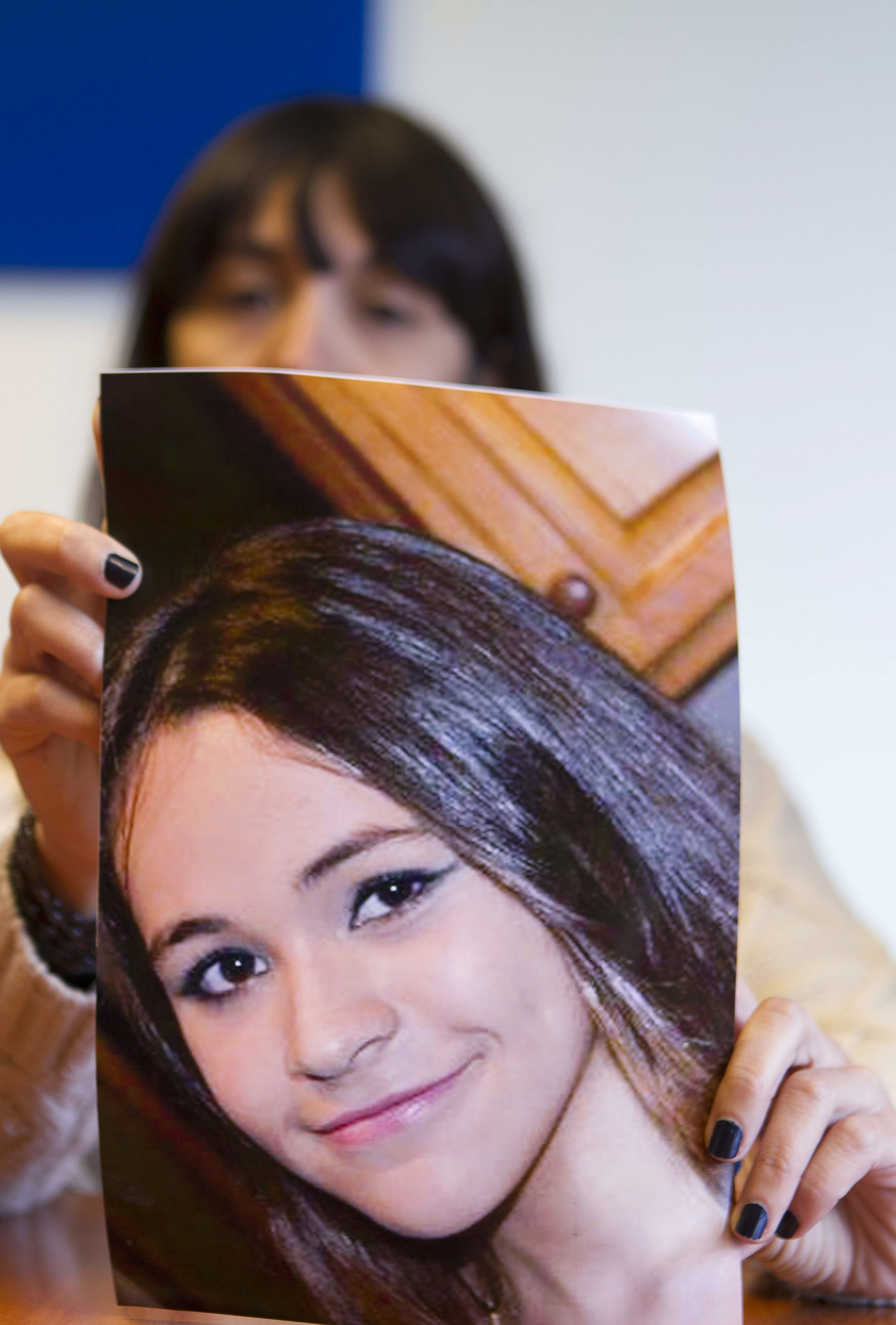 La madre de Maln sostiene una foto de su hija desaparecida.