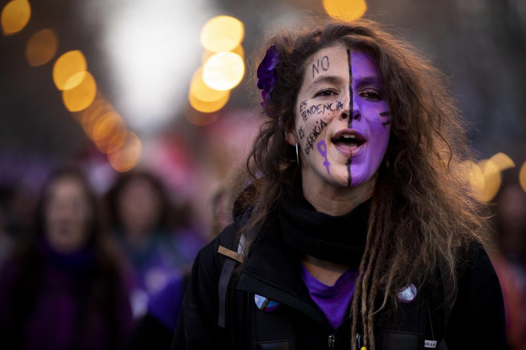 Una mujer, con media cara pintada de color morado, en la Manifestación por el Día Internacional de la Mujer, el 8 de marzo.