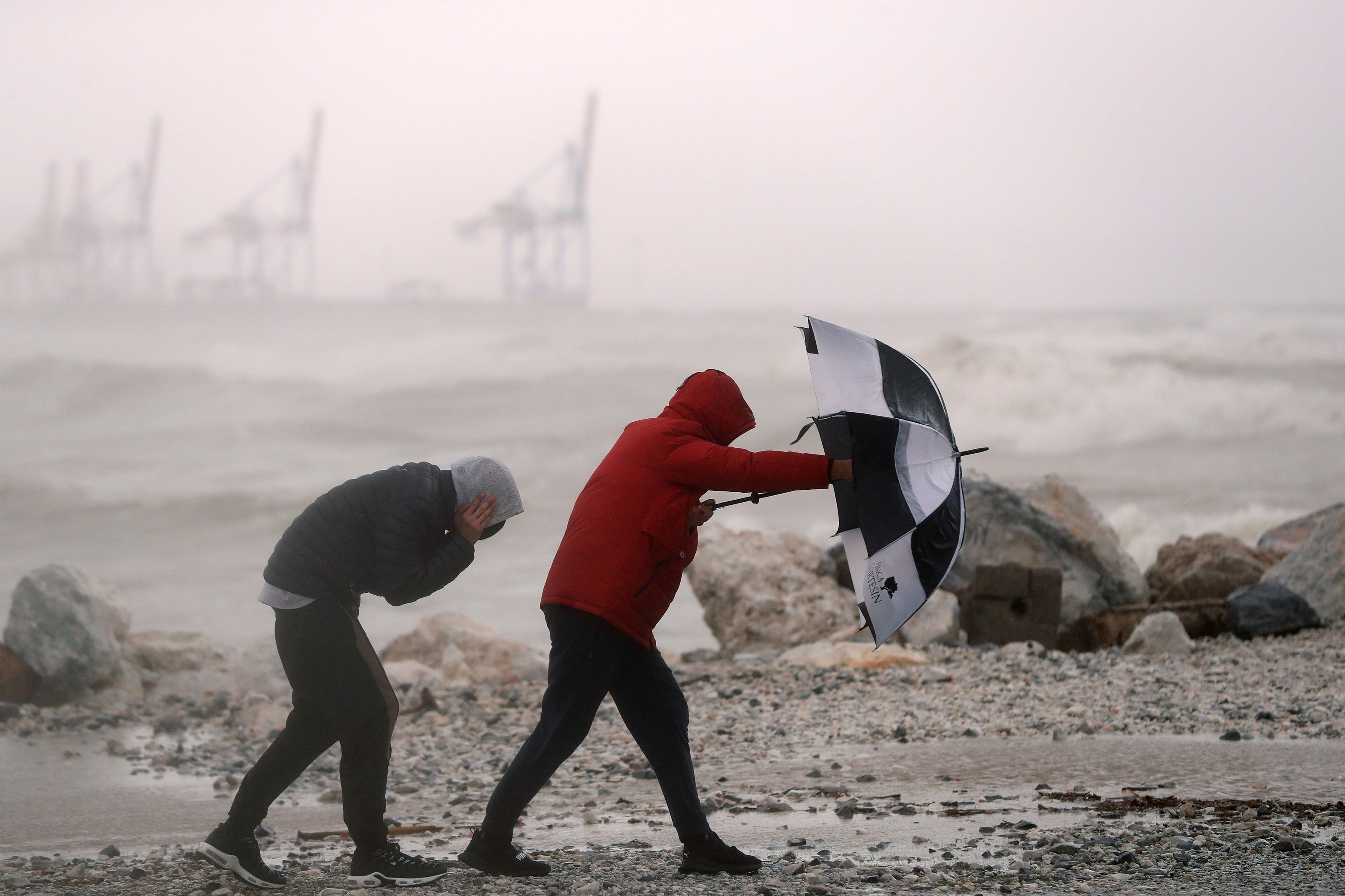 Dos personas se refugian de la lluvia con un paraguas.