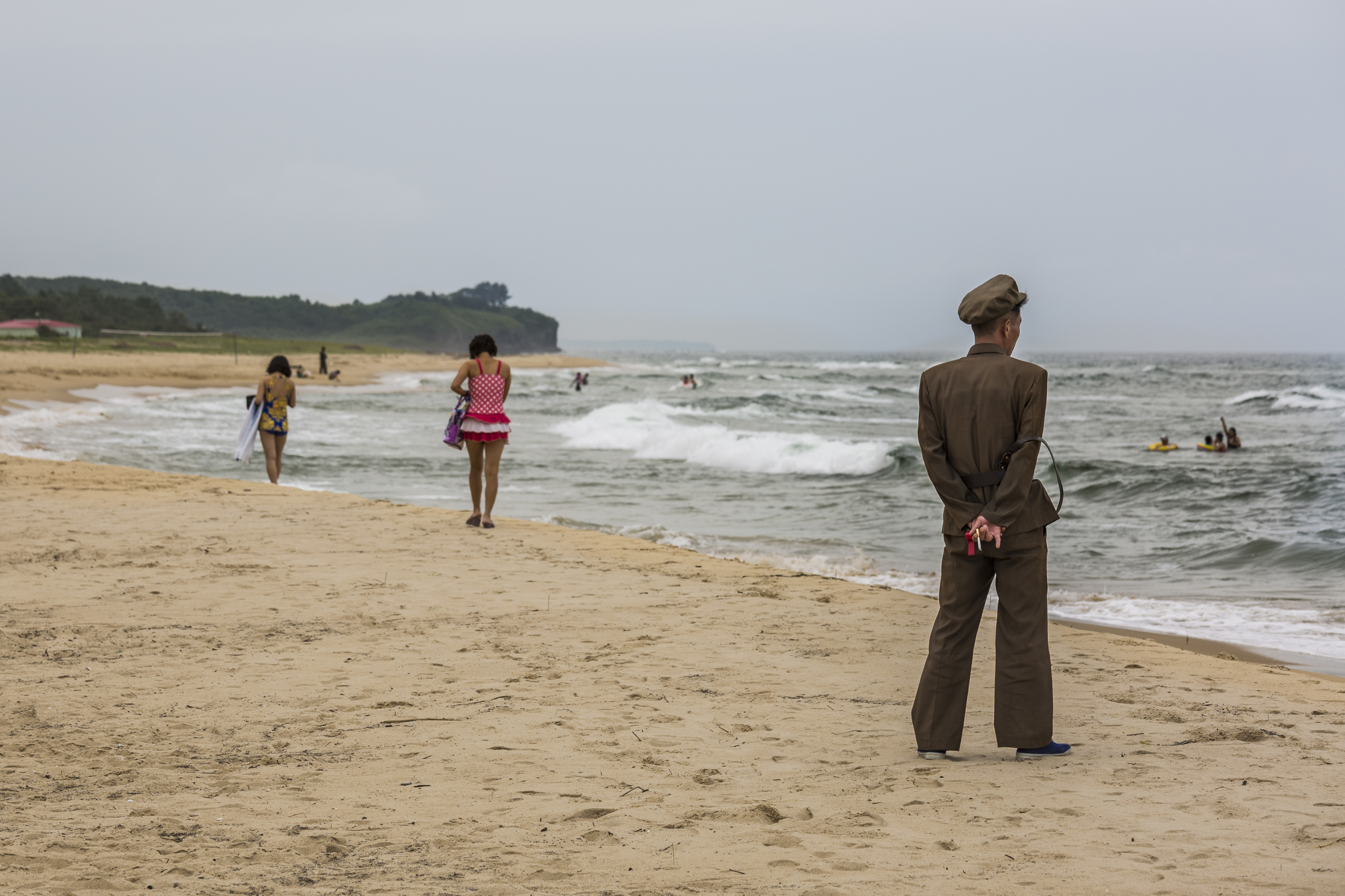Un hombre con uniforme militar vigila a los bañistas en Wonsan.