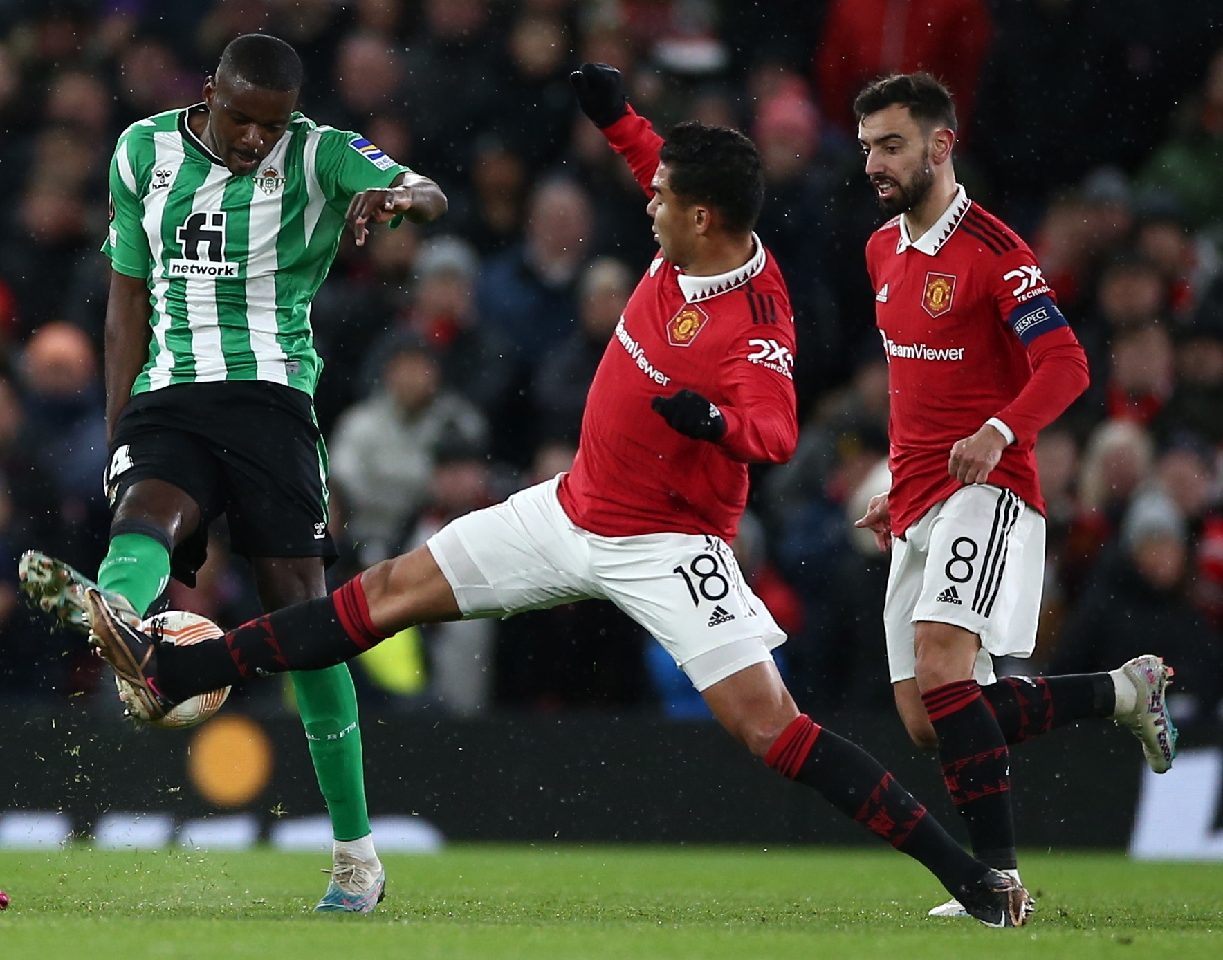 El centrocampista del Manchester United Casemiro trata de parar una jugada de William Carvalho, jugador del Betis, en el partido de ida de los octavos de la Europa League.