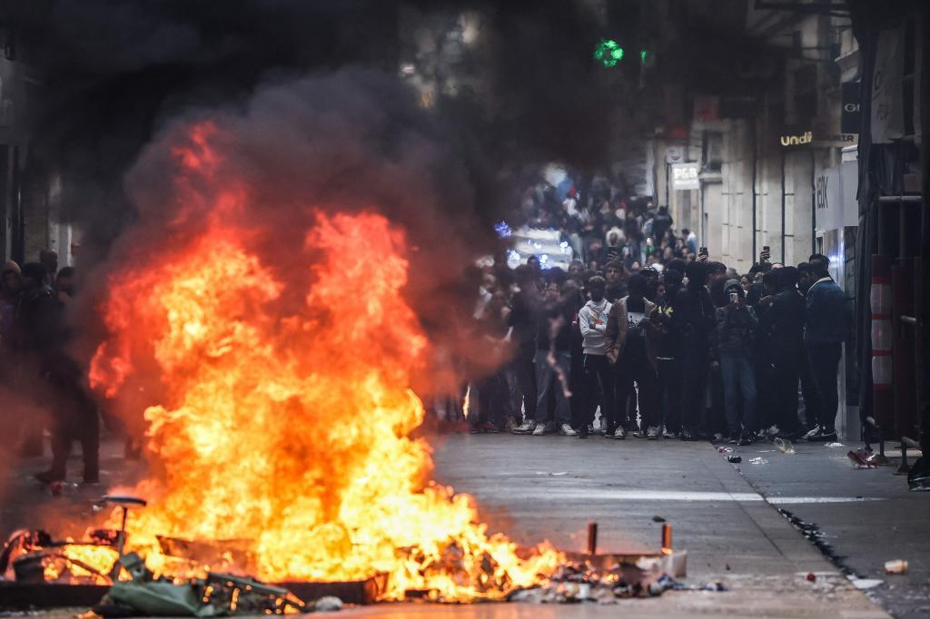 Manifestantes graban con sus teléfonos móviles ante una barricada incendiada en Burdeos.