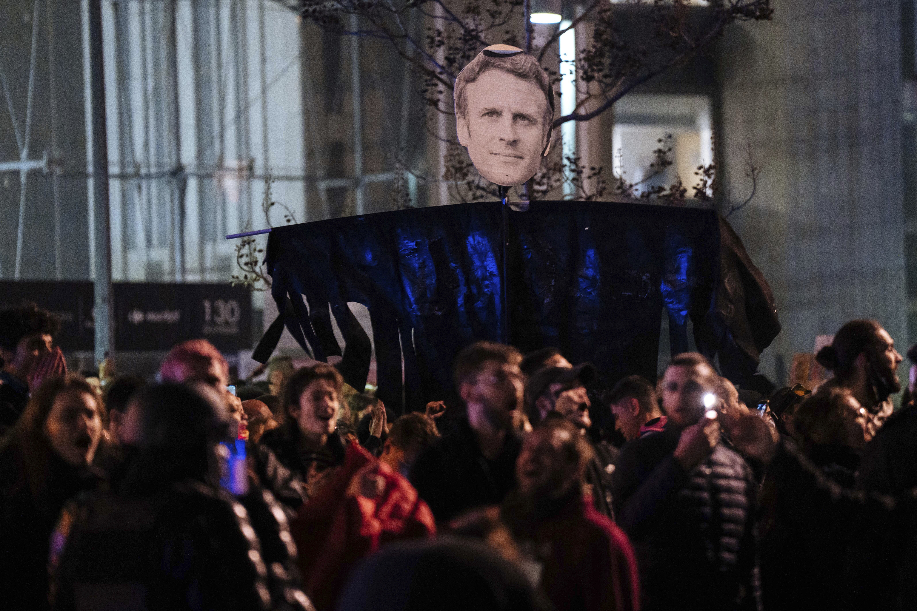 Manifestantes con un retrato de Emmanuel Macron, en París.