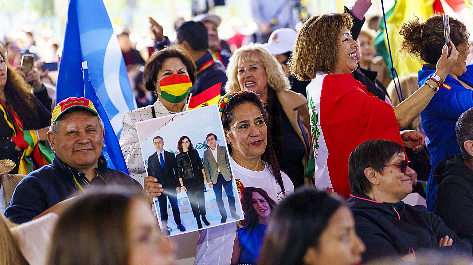 Residentes latinos portan fotos y camisetas de los lderes populares, junto a banderas de sus pases, en el acto de San Blas.