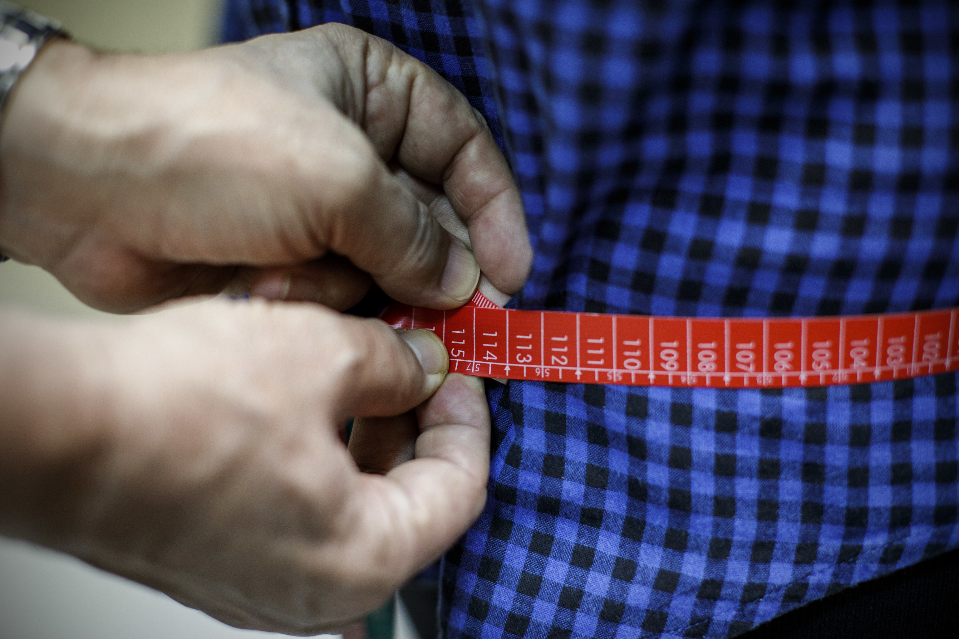 Un investigador mide la talla de cintura de un hombre.