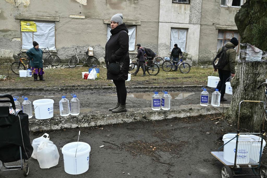 Una residente local junto a bidones de agua de la ayuda humanitaria recibida en la ciudad de Chasiv Yar, en Donetsk.