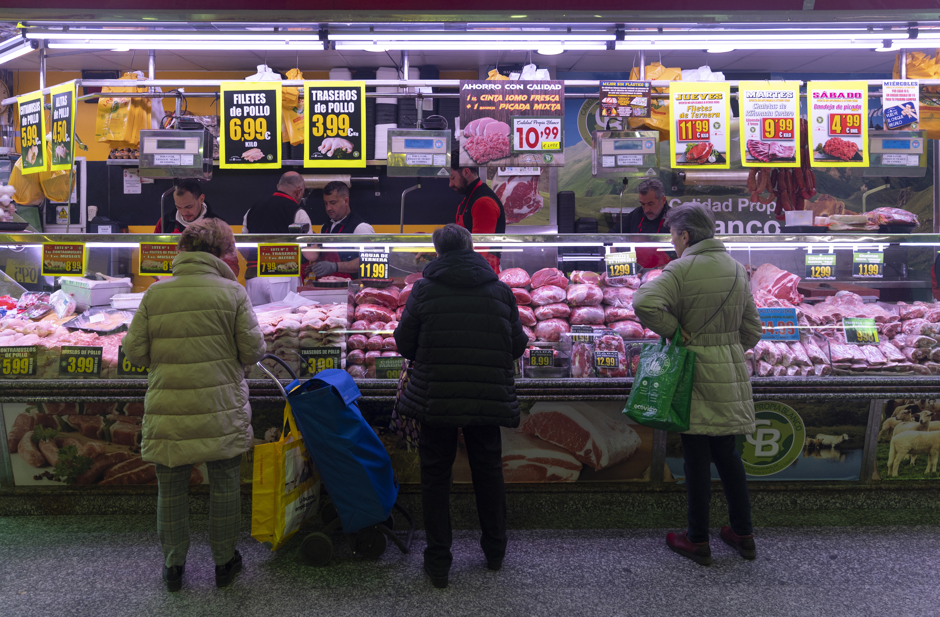 Varias mujeres compran en una carnicería en un mercado