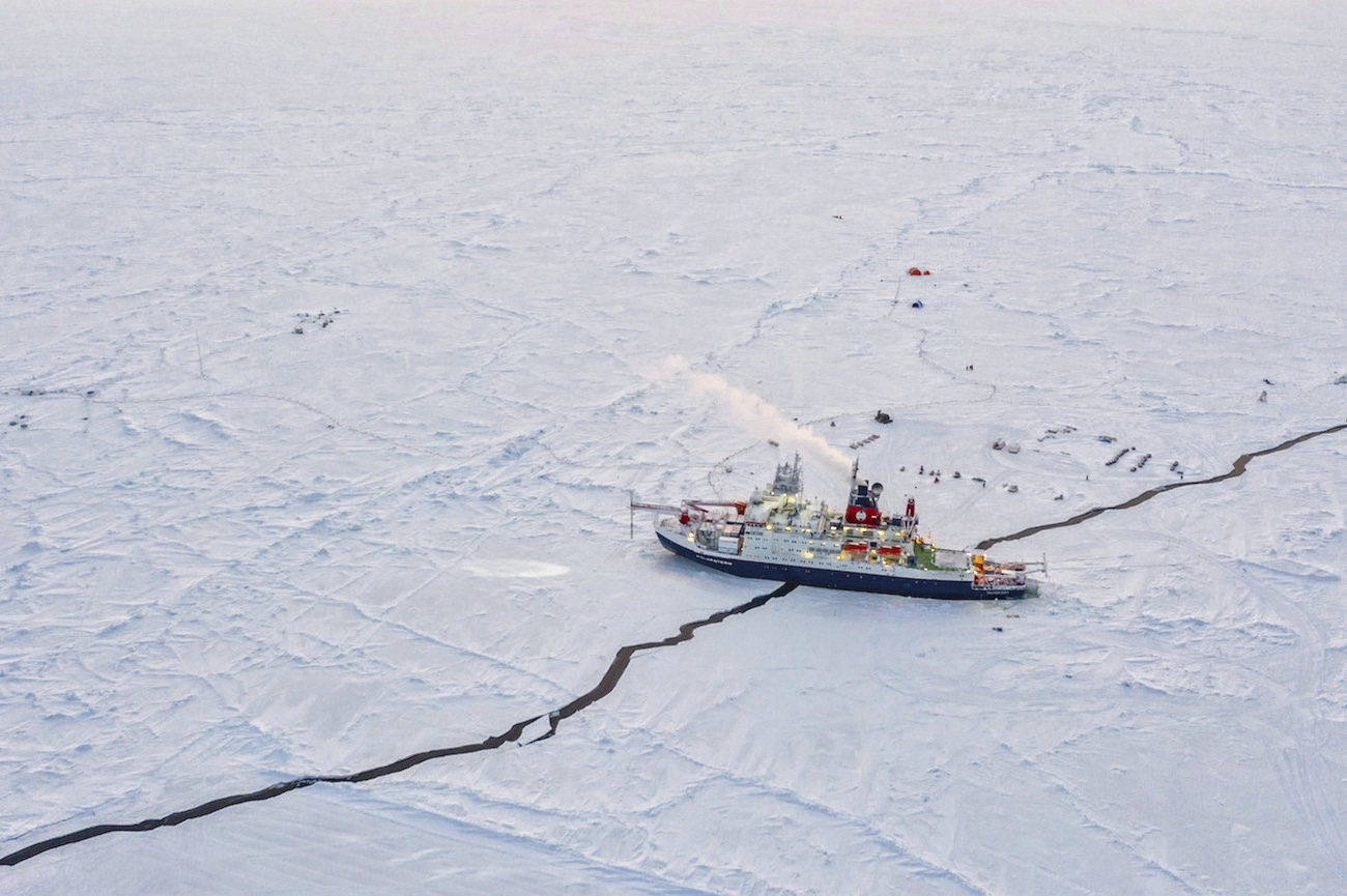 Un barco atraviesa una fisura en el hielo del Ártico.