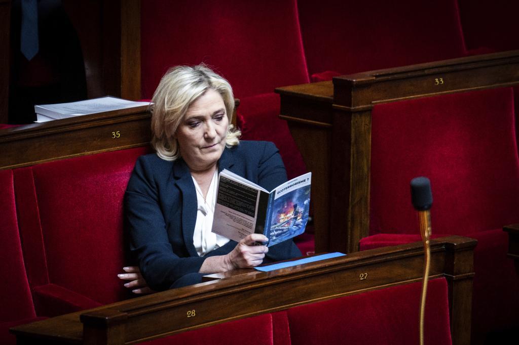 Le Pen lee un libro de 'ecoterrorismo' en la Asamblea Nacional.