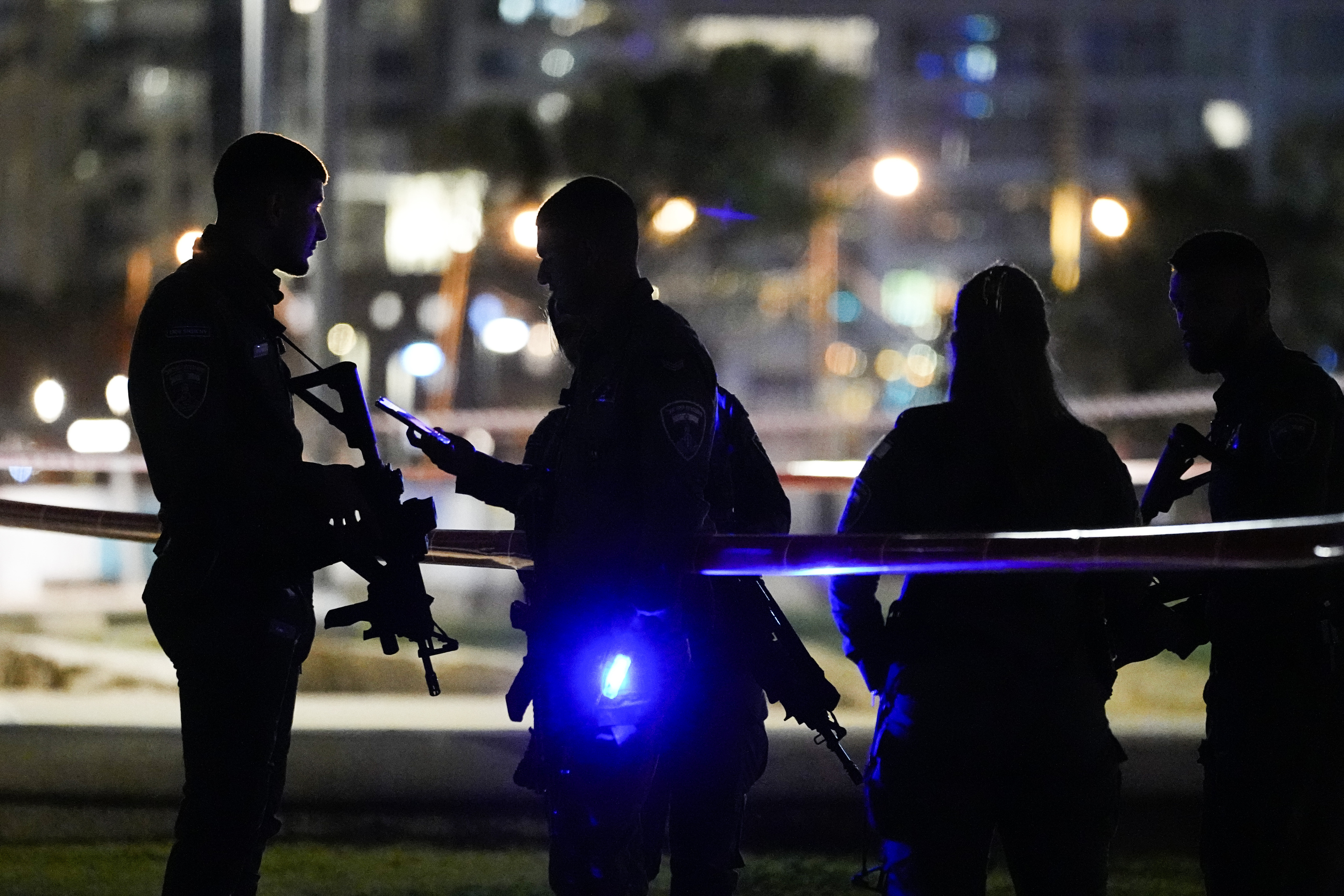 Israeli police stand at the scene of an an attack in  lt;HIT gt;Tel lt;/HIT gt;  lt;HIT gt;Aviv lt;/HIT gt;, Israel, Friday, April 7, 2023. Israeli police said a car rammed into a group of people near a popular seaside park before flipping over. Police said they shot the driver of the car. Israel's rescue service described the incident as a shooting attack. (AP Photo/Ariel Schalit)