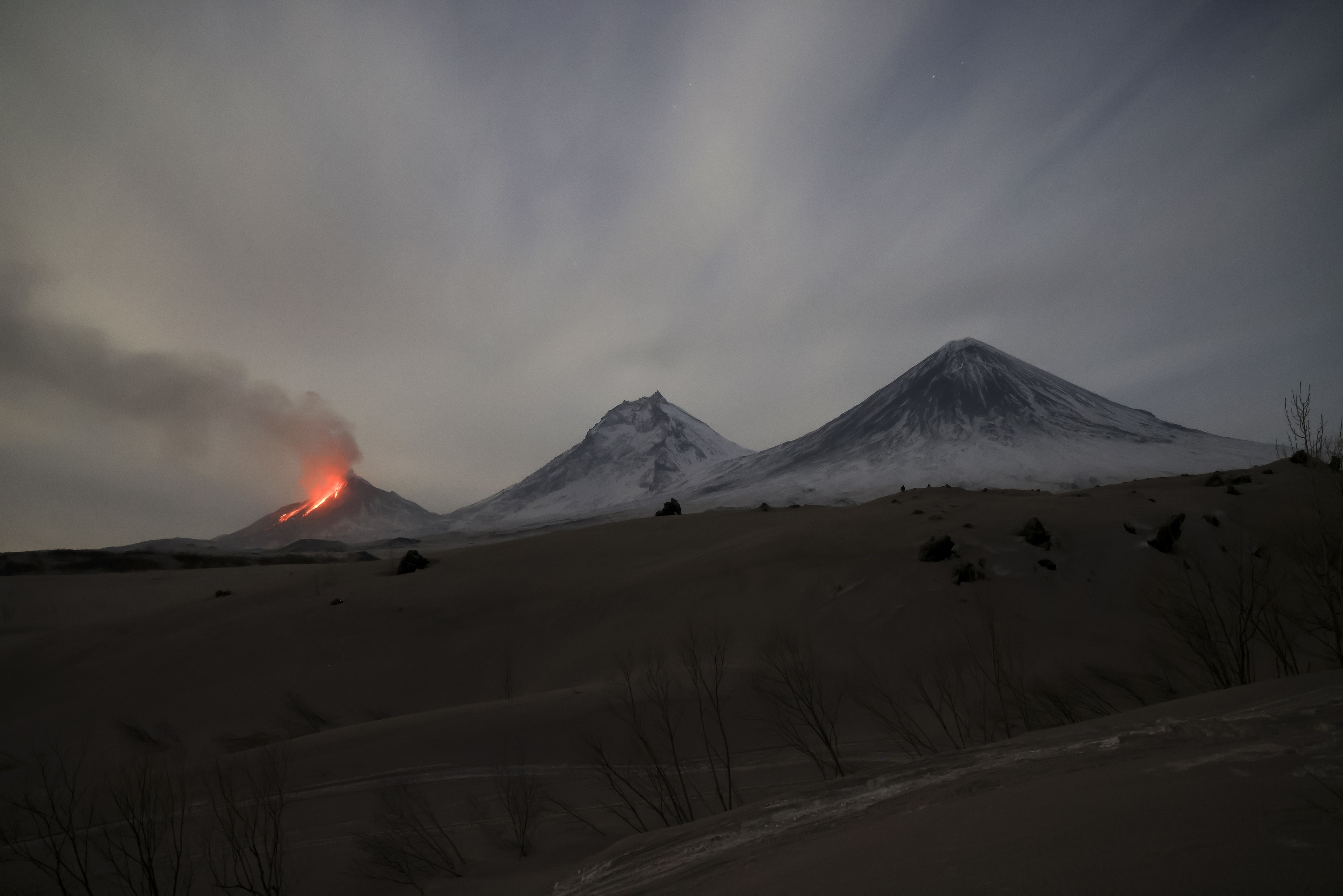 Lava y vapores son visibles durante la erupcin del volcn Bezymianny, izquierda, con el volcn Kamen, centro, y el volcn Klyuchevskaya sopka, derecha, en la pennsula de Kamchatka en Rusia, sbado, 8 de abril de 2023. El viernes, el volcn Bezymyanny emiti cenizas de hasta 10.000 metros de altura. Al volcn se le asign el cdigo de peligro rojo para la aviacin. La pennsula de Kamchatka, que se adentra en el ocano Pacfico a unos 6.600 kilmetros al este de Mosc, es una de las zonas con mayor concentracin de actividad geotrmica del mundo, con unos 30 volcanes activos.