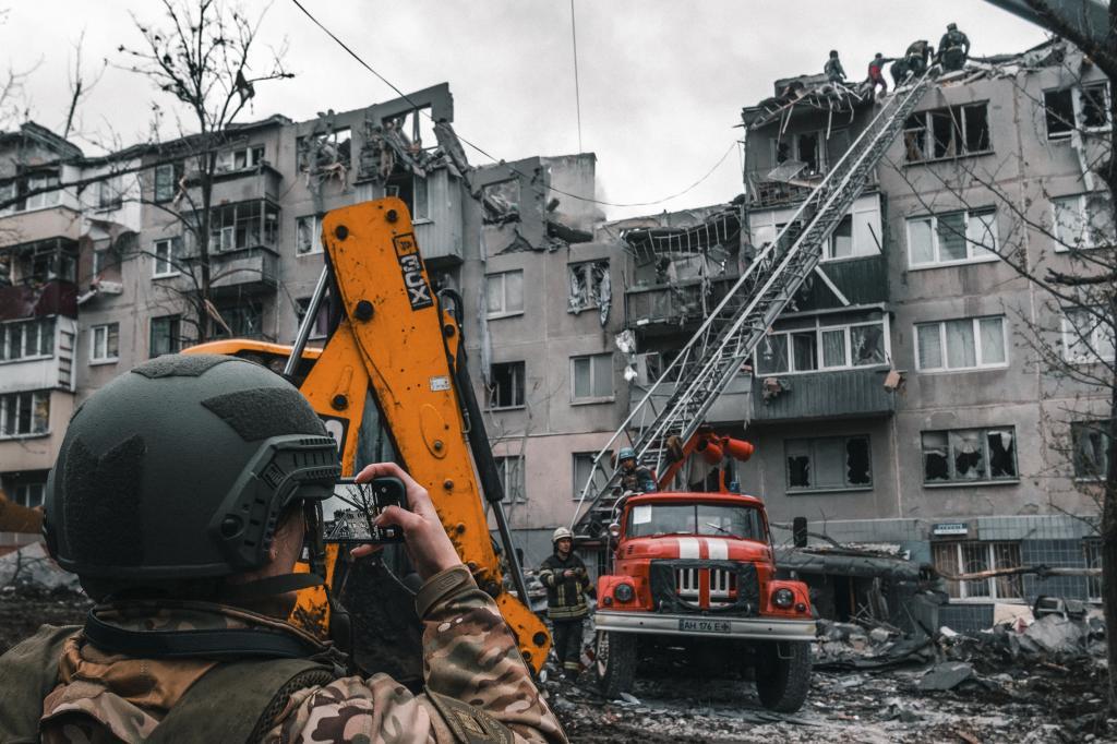Una militar ucraniana fotografa el escenario de uno de los ataques.