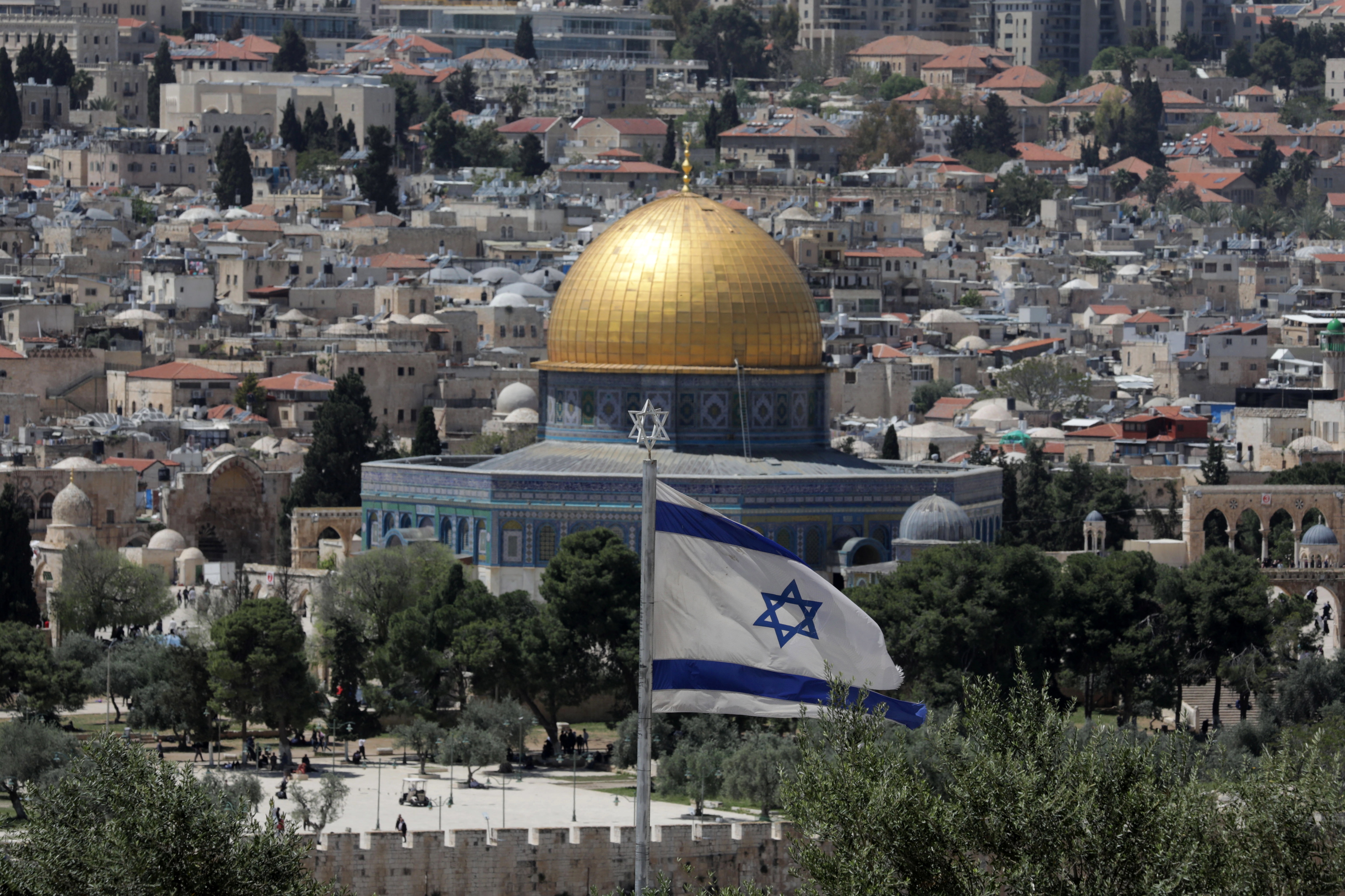 La bandera de Israel ondea con la Mezquita de la Roca de fondo.
